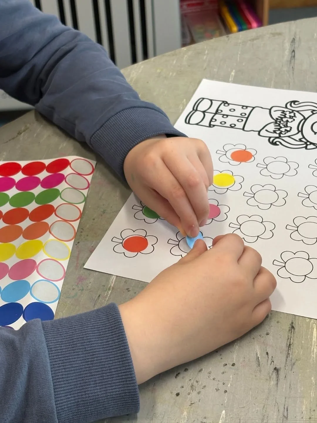 Senior Infants working on their fine motor skills. Peeling off stickers and sticking them down.
