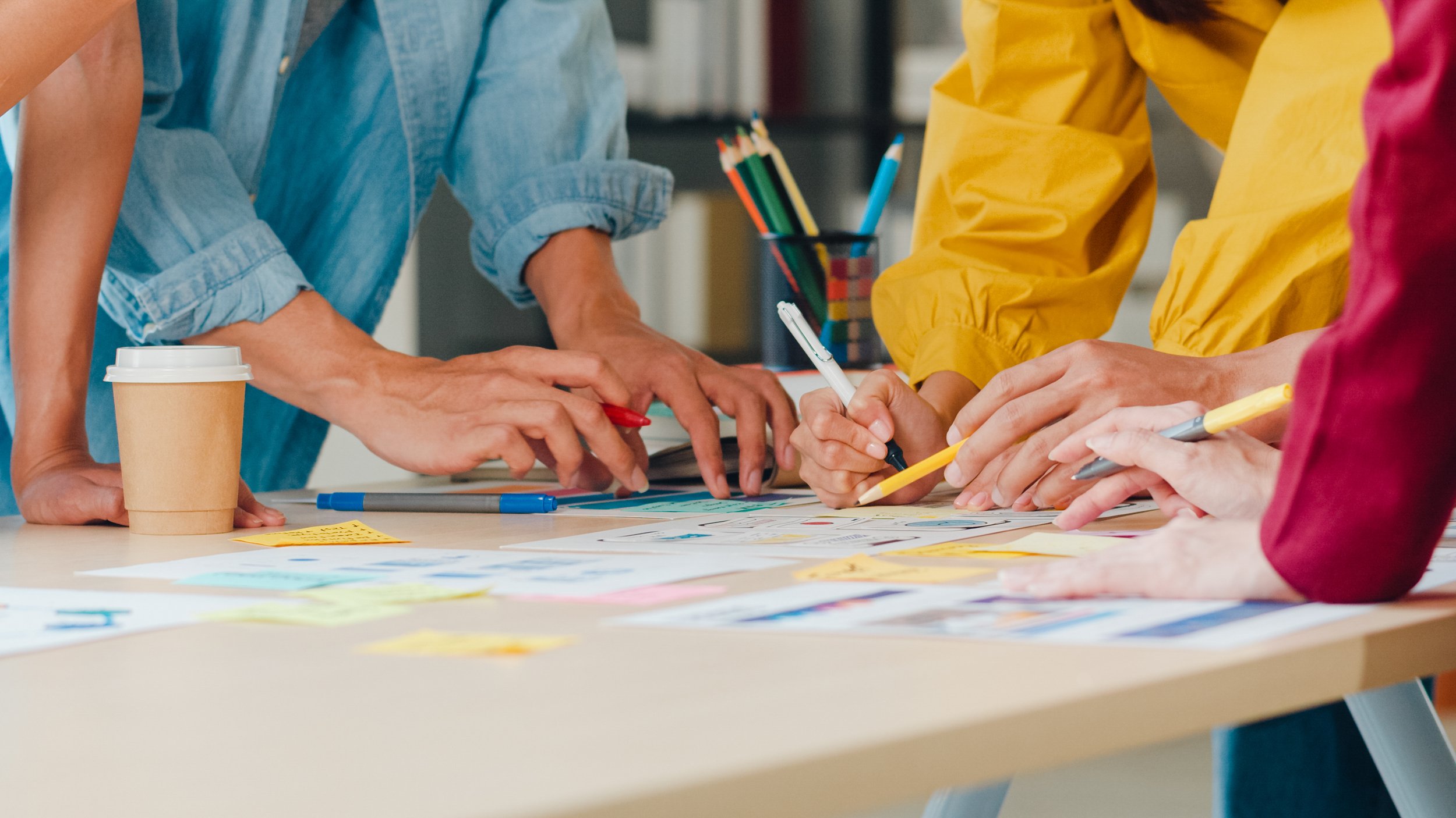 people working collaboratively on a table surface.
