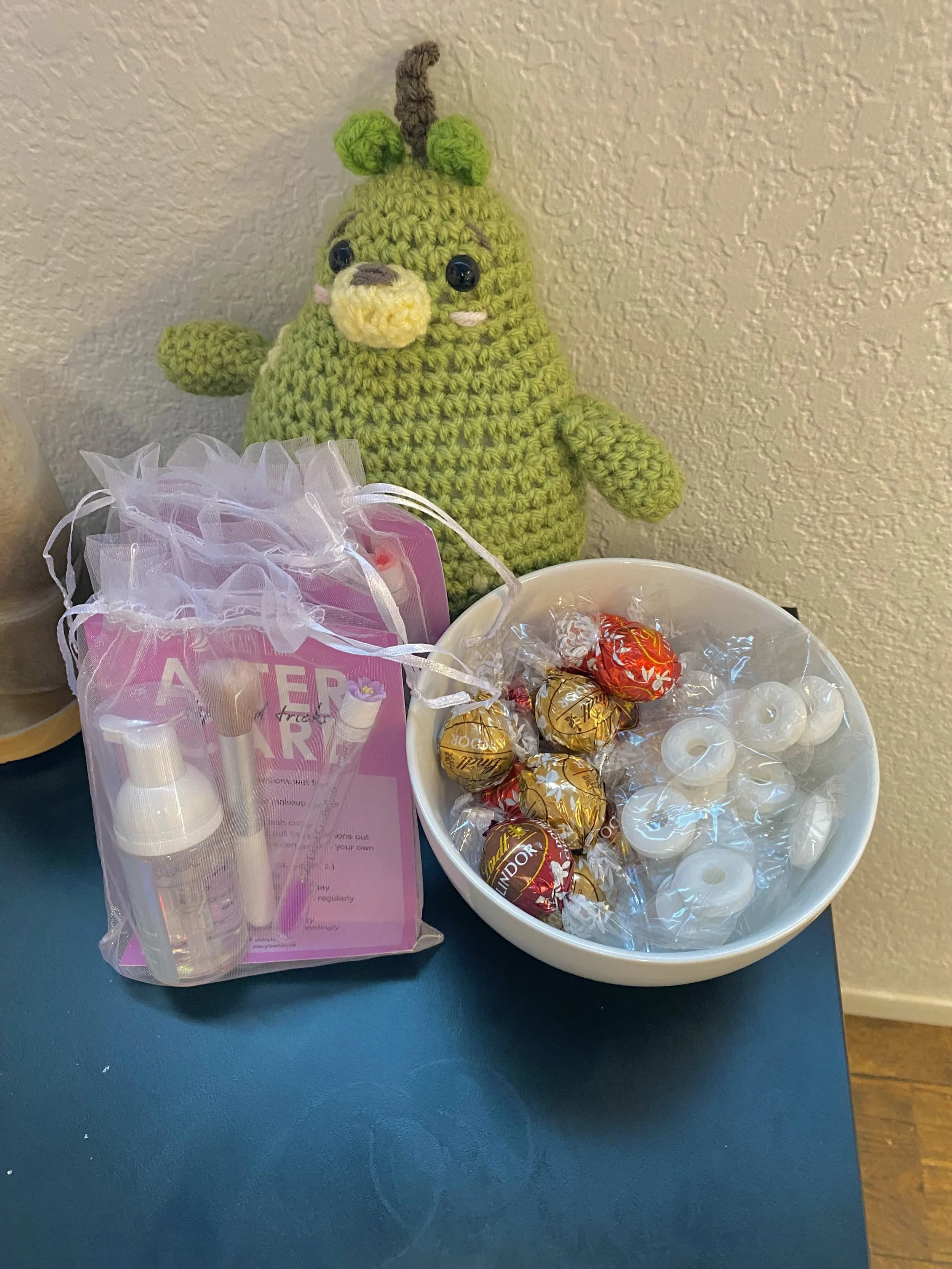 free snack bar with chocolate truffles and mints in a white bowl with other gift bags near by 