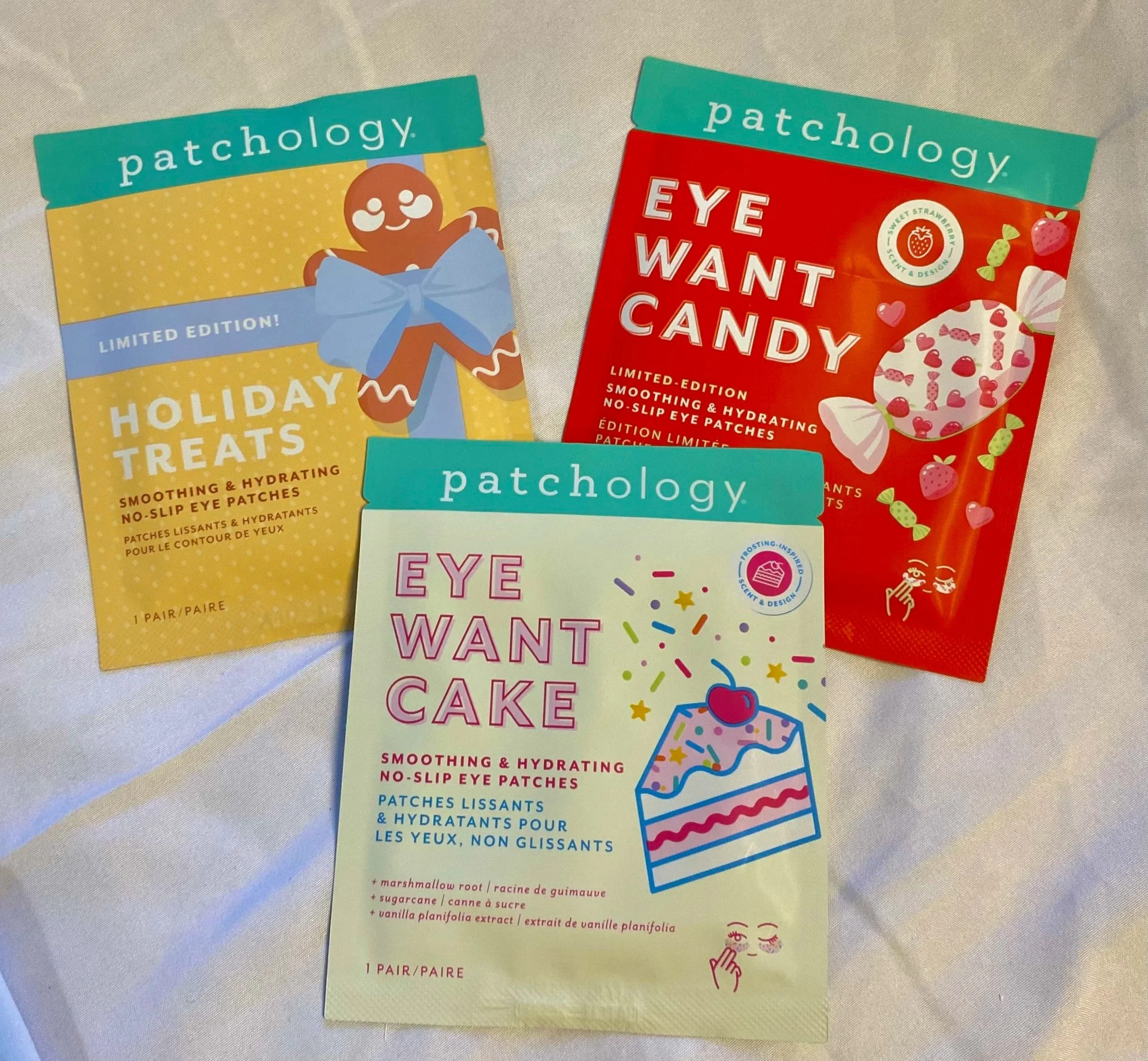 Three packets of patchology eye patches on a white surface, with colorful packaging design, each labeled with different flavors and benefits.