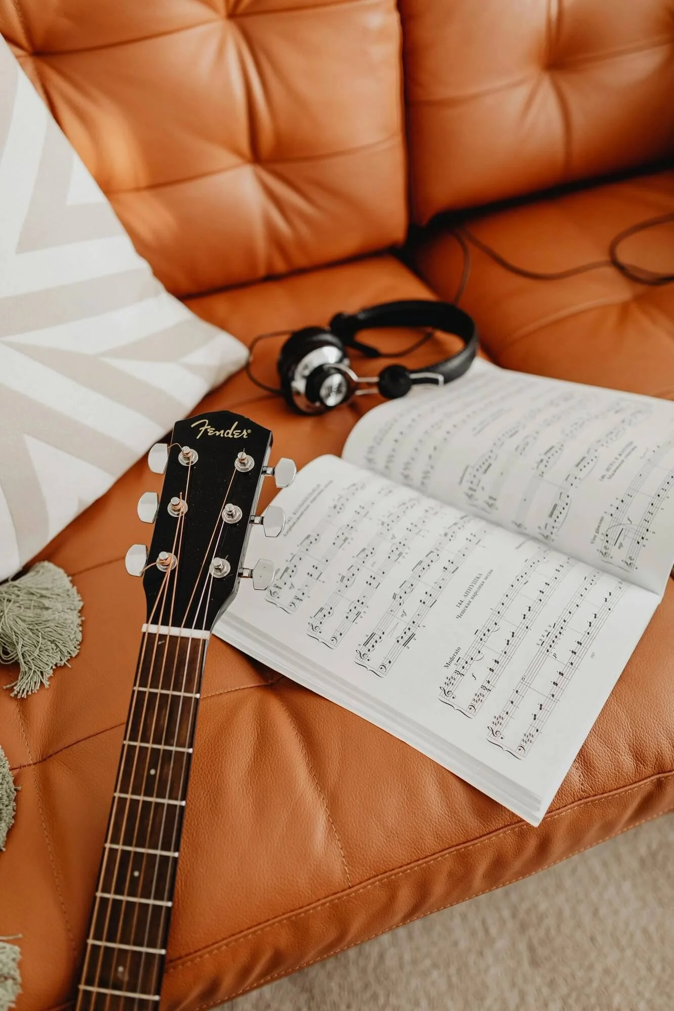 leather coach with guitar, headphones, music book