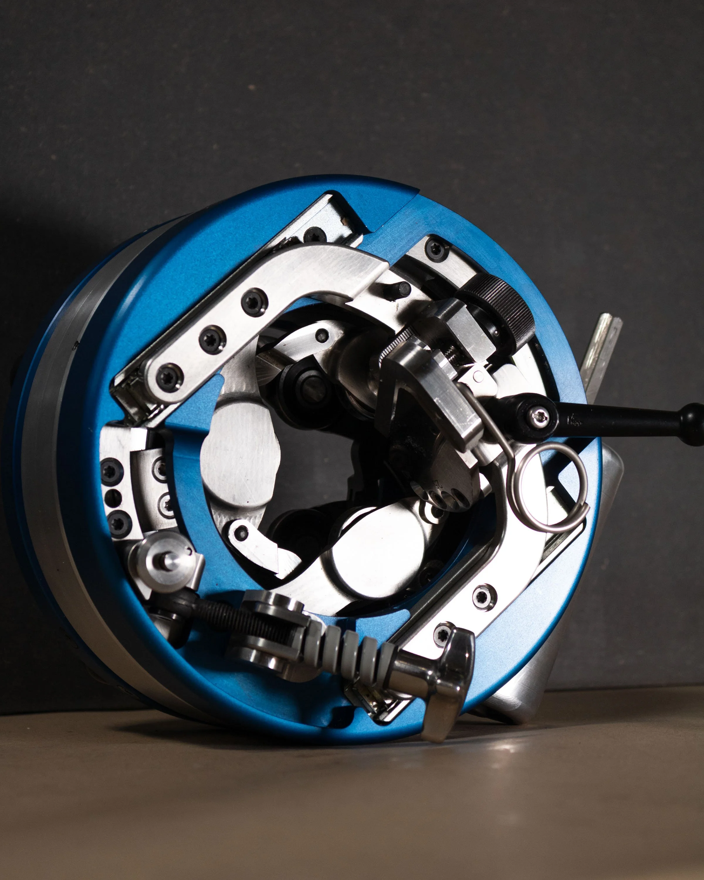 A Global Cable  Rev 110 with metal parts and blue accents, featuring various screws, levers, and intricate components.