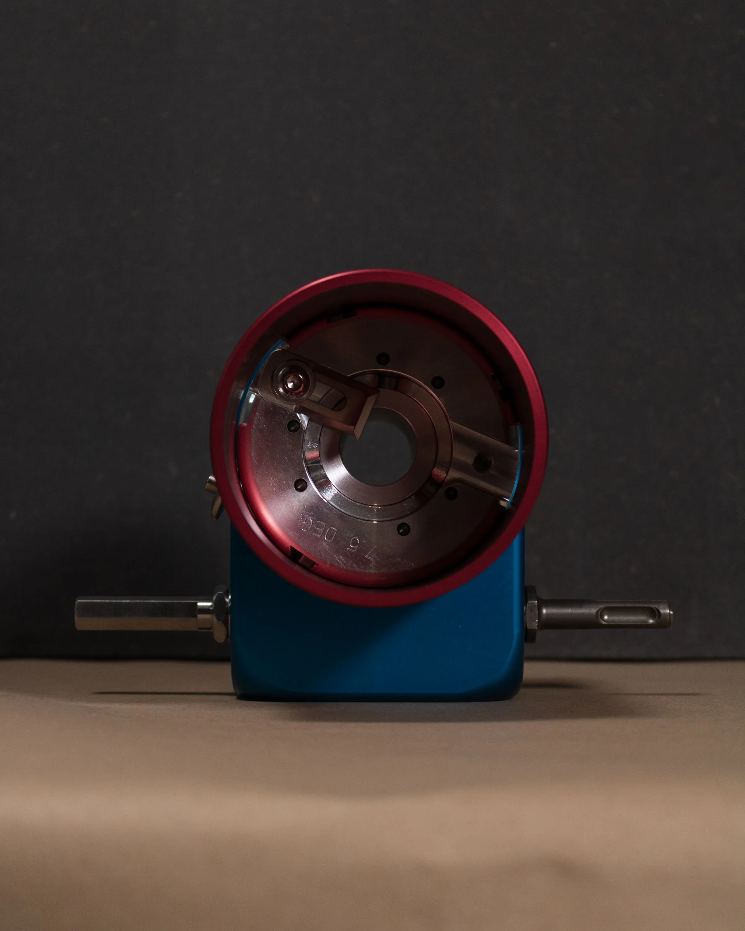 A dental mold with a red and blue base. The mold is circular and includes small metal parts arranged inside.