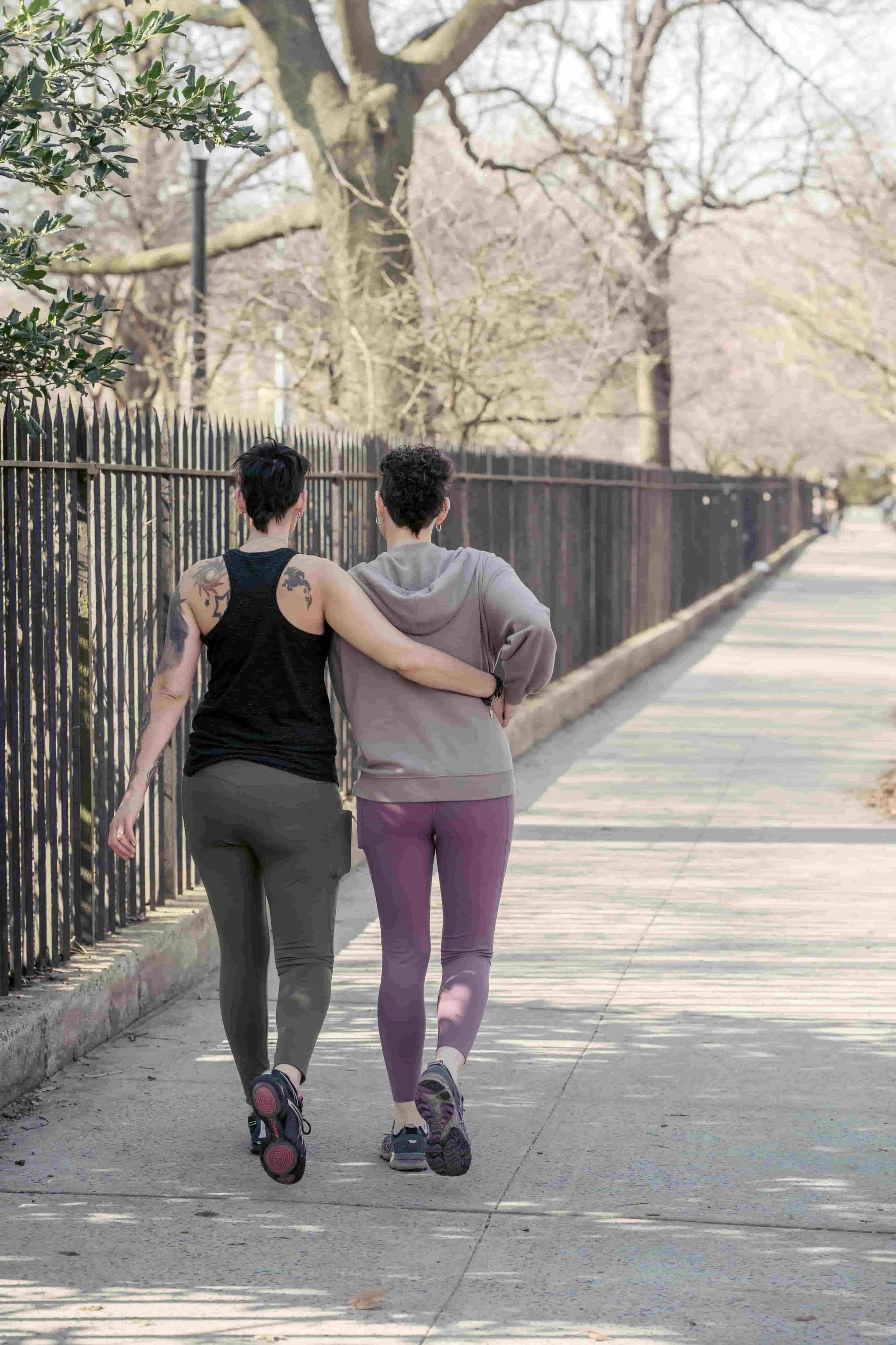 Two female runners supporting themselves during and after a run