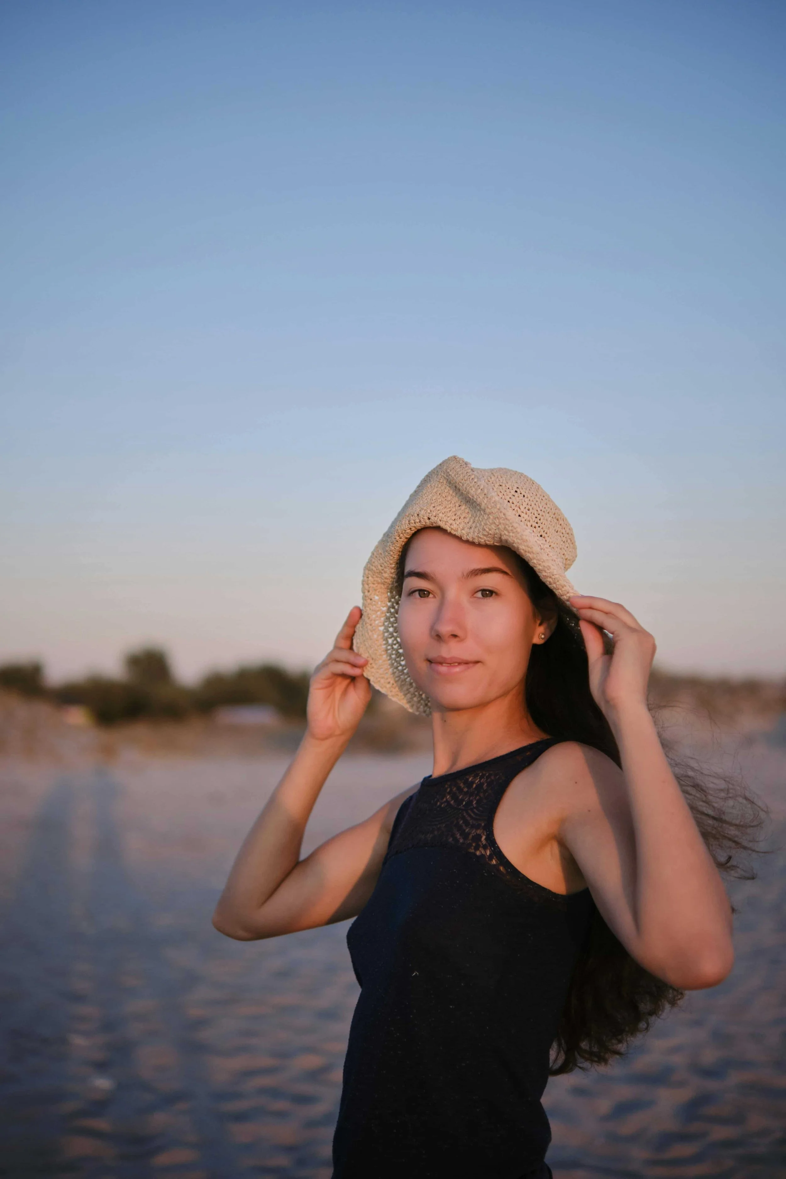 Asian American woman smiling on the beach following therapy for high achievers