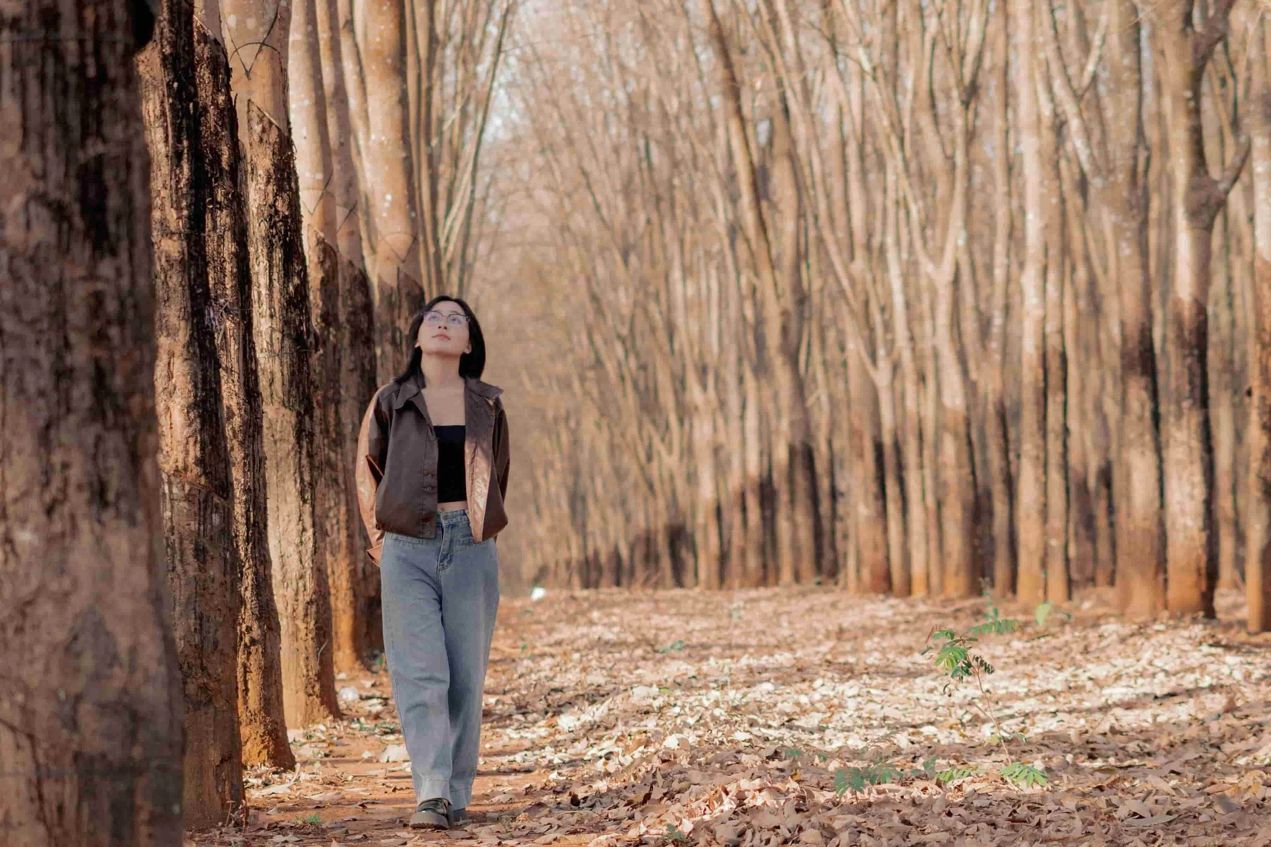 Asian American woman walking and reflecting thoughtfully as she walks outdoors