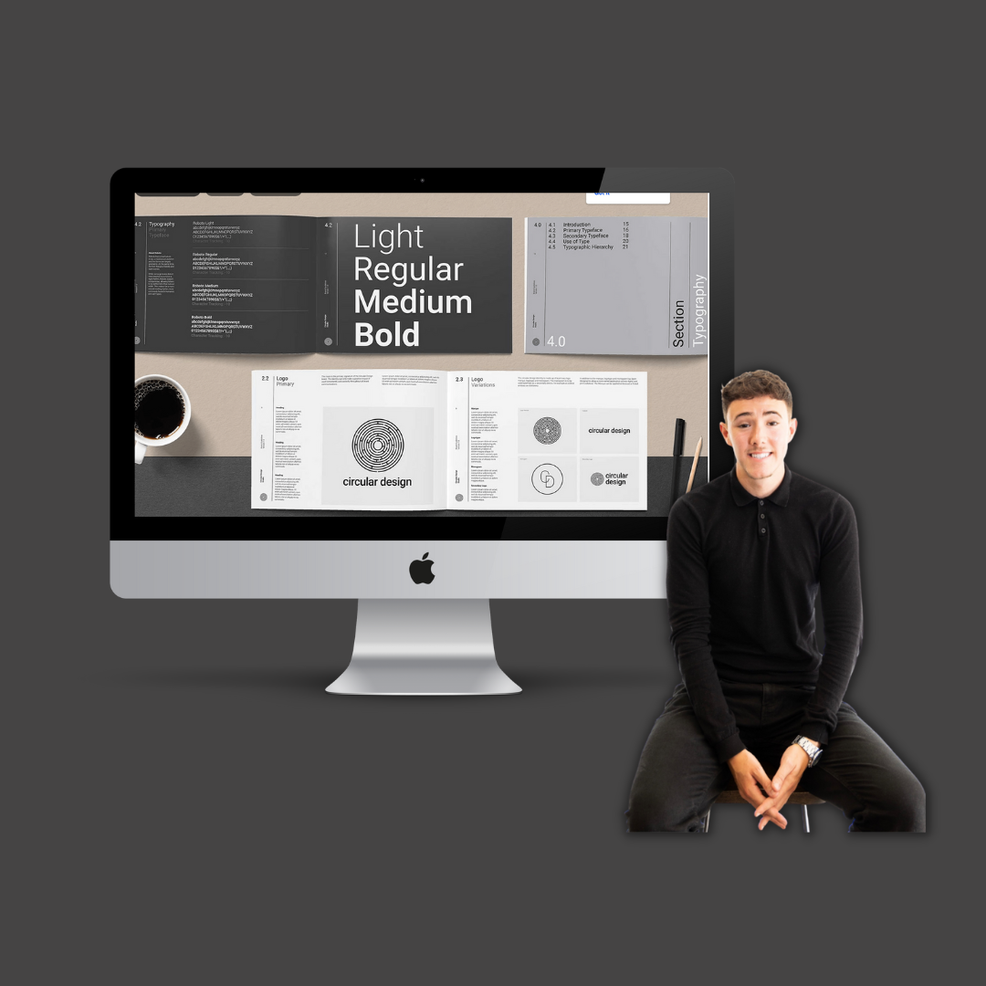 A man in a black sweater sitting on a stool in front of a dark gray background, with a large iMac displaying a design layout on the screen.