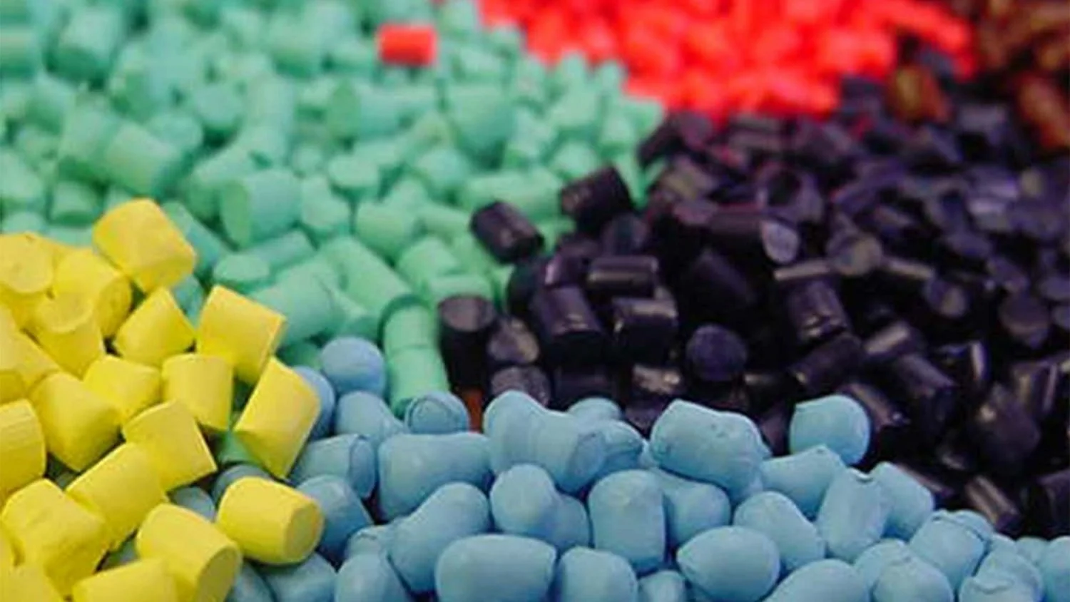 Close-up of colorful chalks arranged in rows, including yellow, light blue, green, black, and red chalks.
