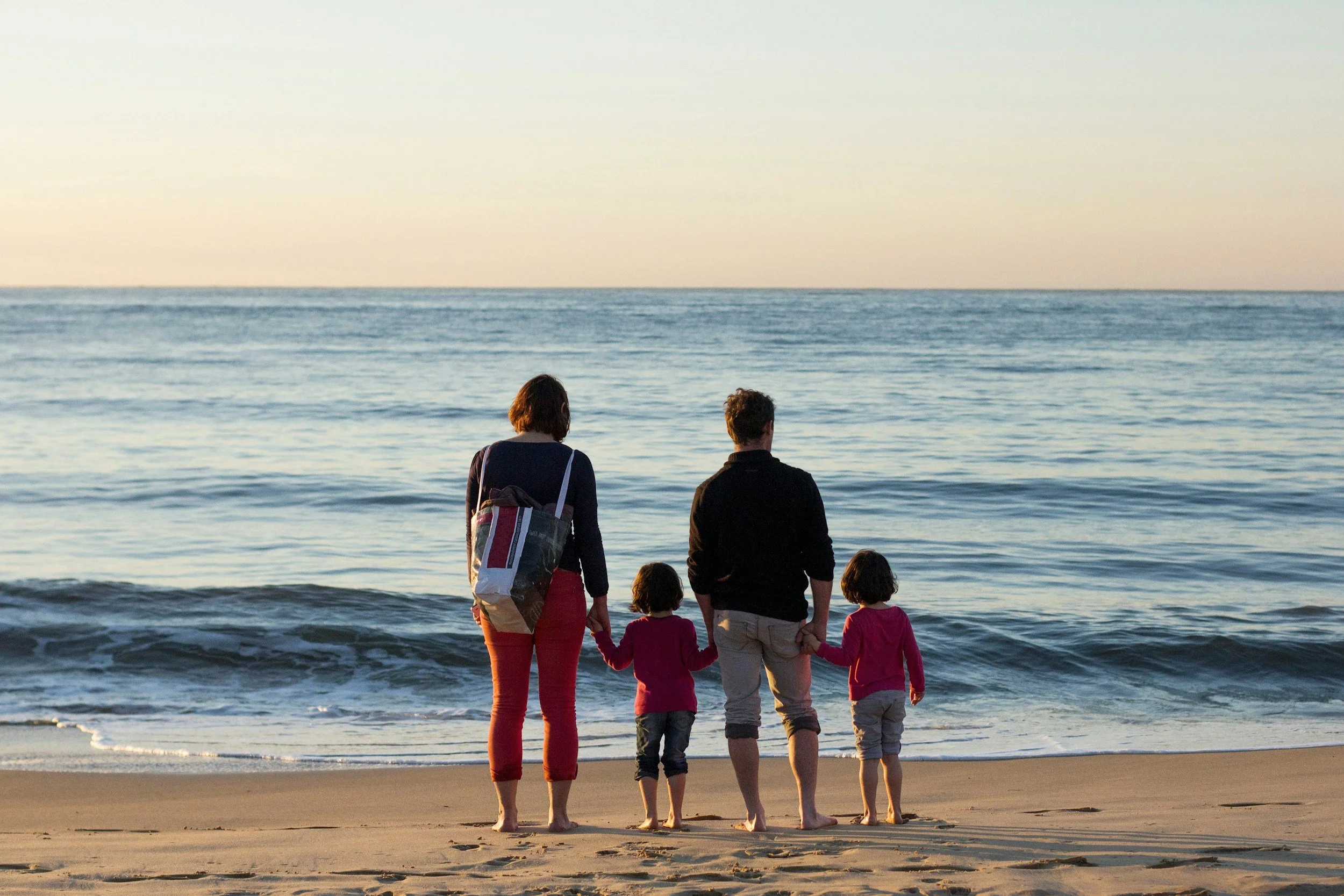 Grandparents and grandchildren walking on the beach, representing family legacy planning in Virginia Beach