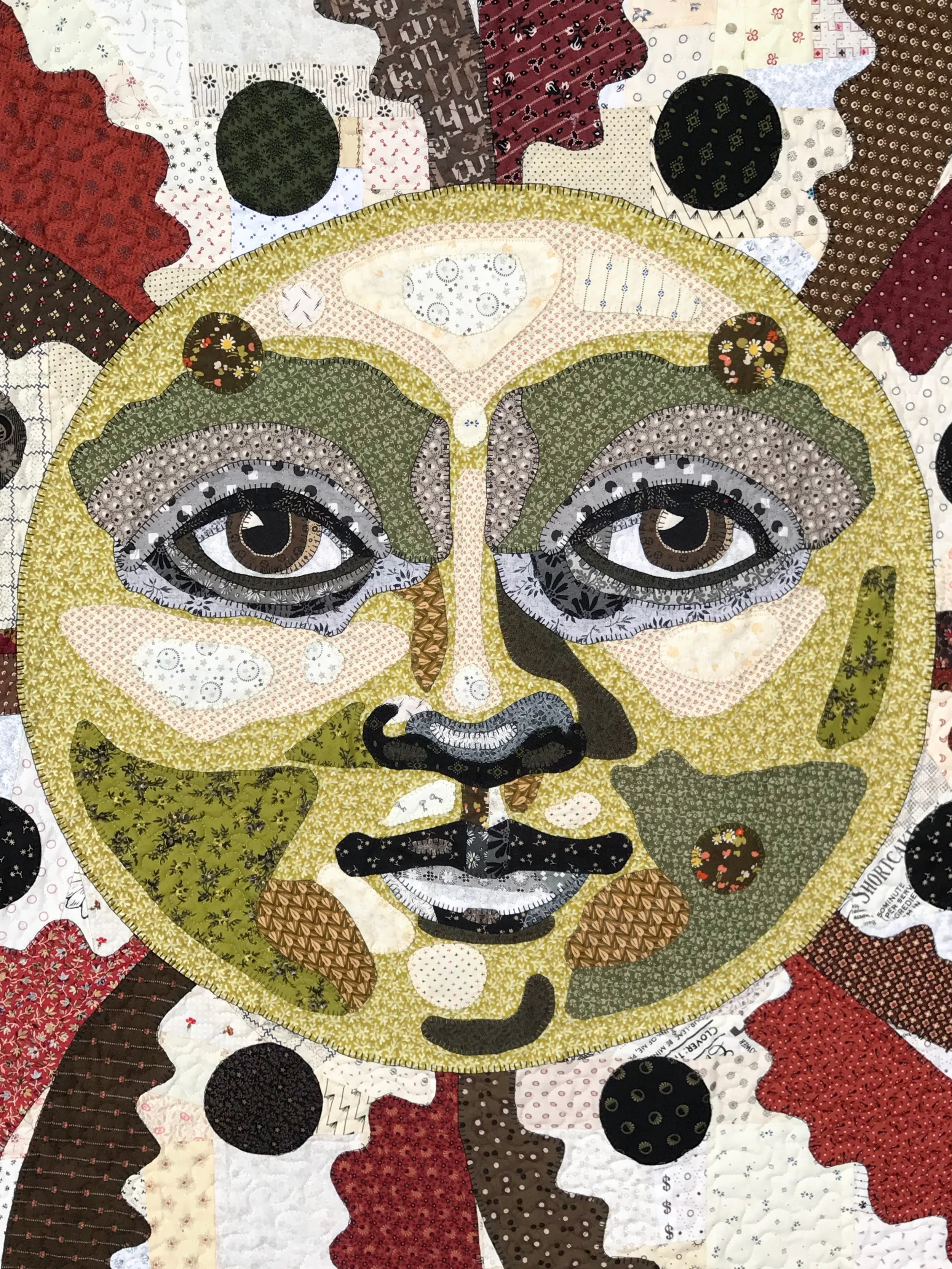 applique face quilt featuring a portrait of sun man