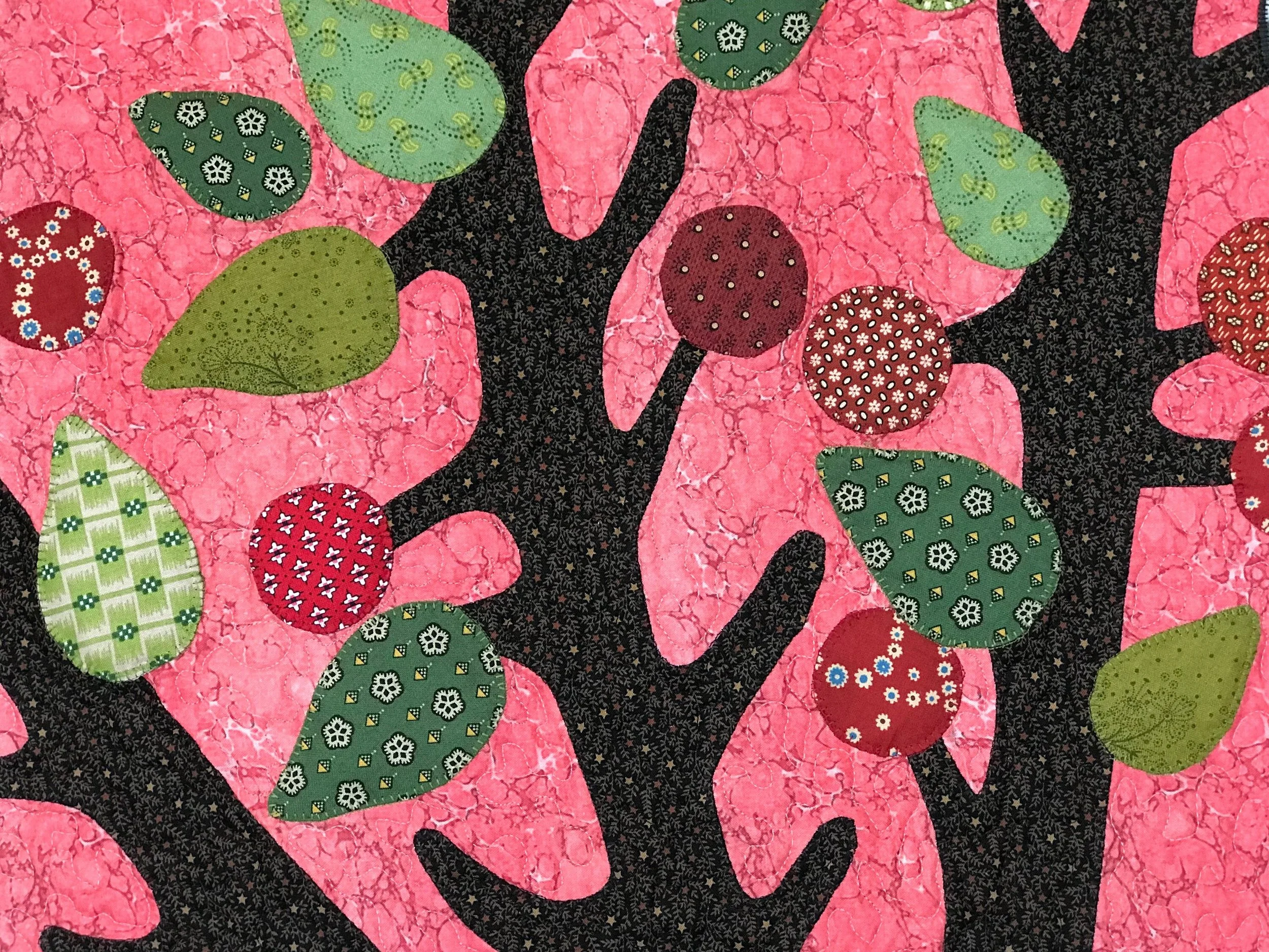 folk art applique quilt with branches of a tree bearing fruit and leaves