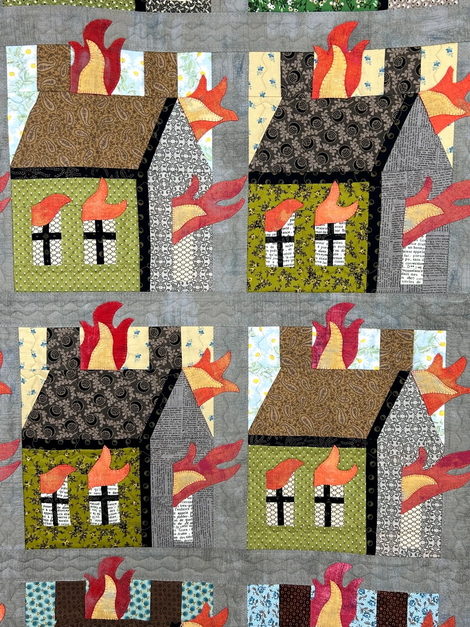 art quilt with houses and fire motif in distressed muslin