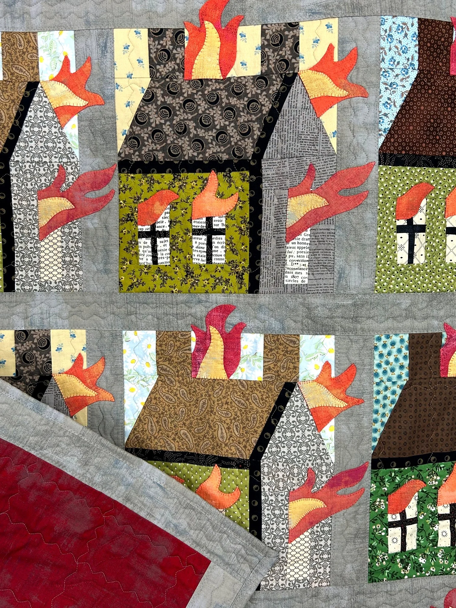 unique wall hanging quilt with folk art design of burning houses
