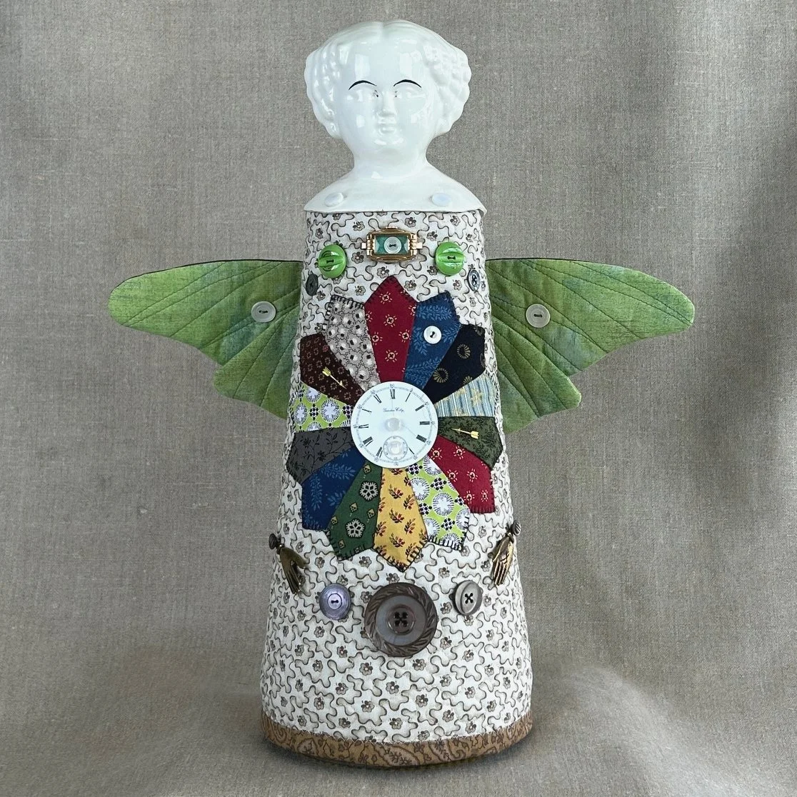 handmade totem figurine with porcelain head and an assemblage of vintage buttons and brass findings