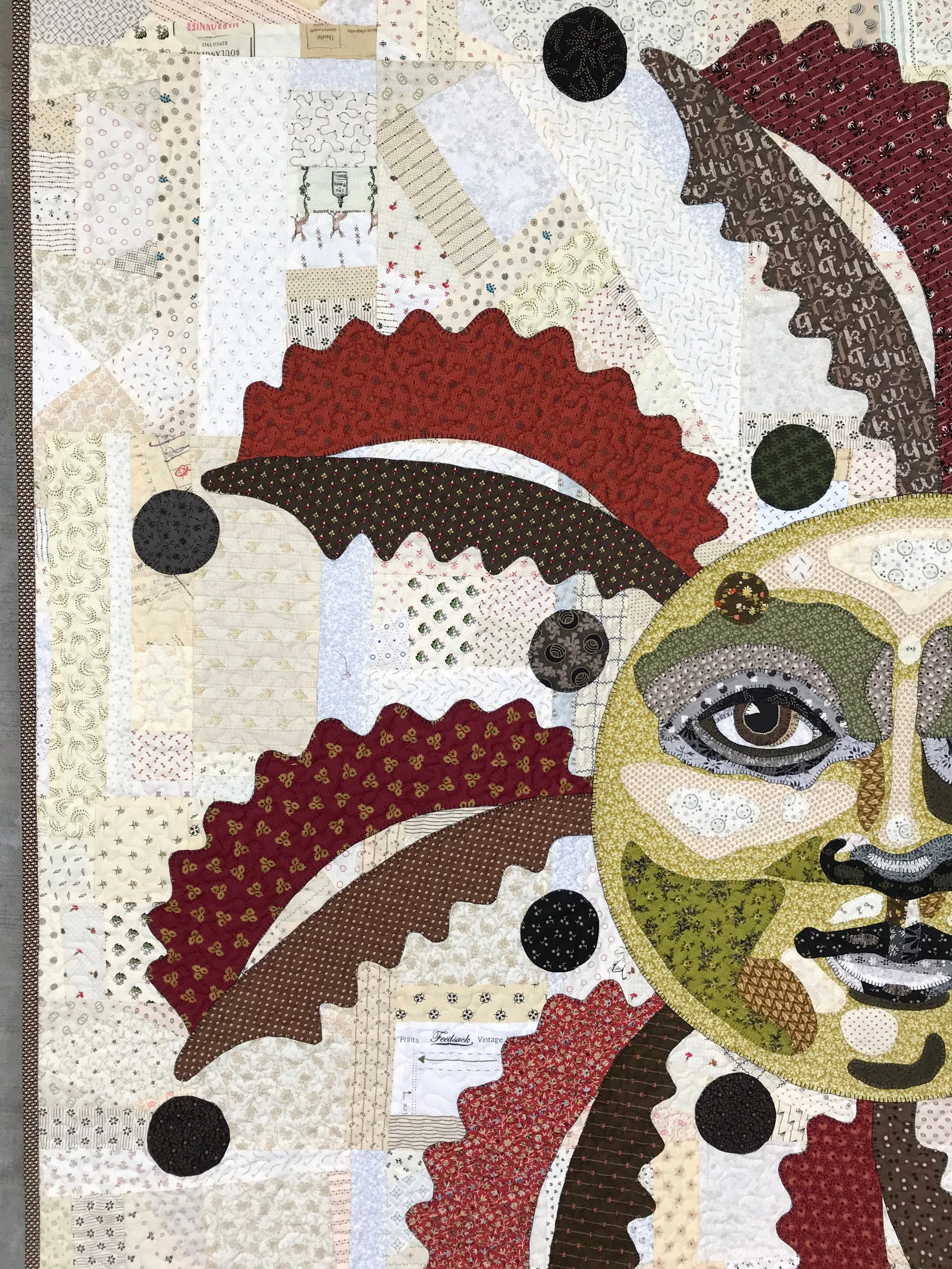 detail of art quilt featuring applique fronds in red