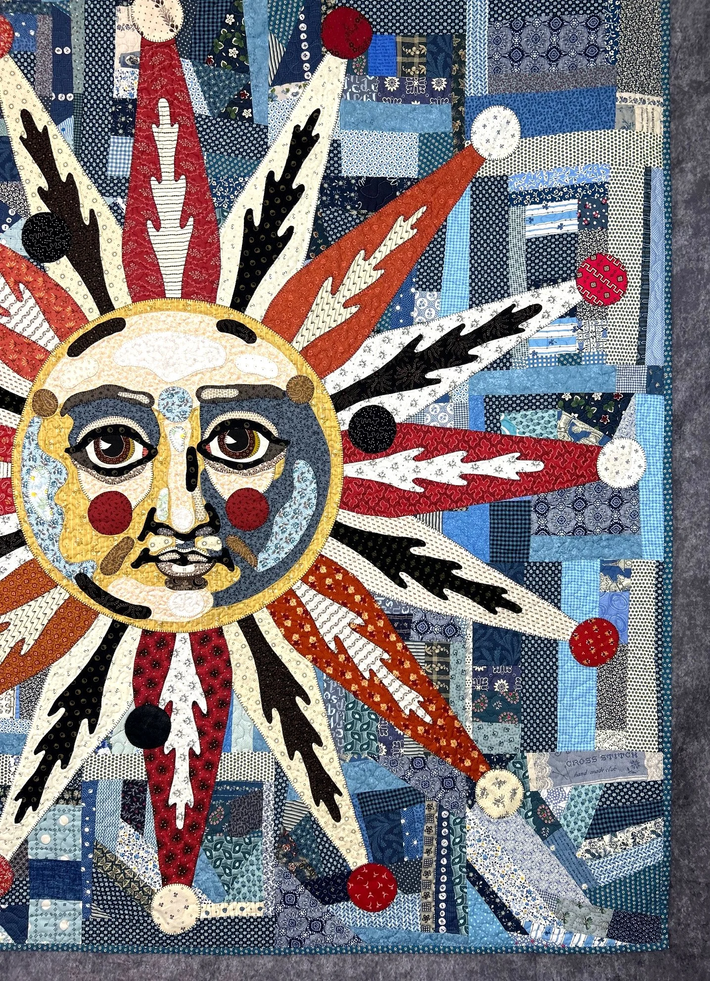 crazy quilt wall hanging featuring an applique sun