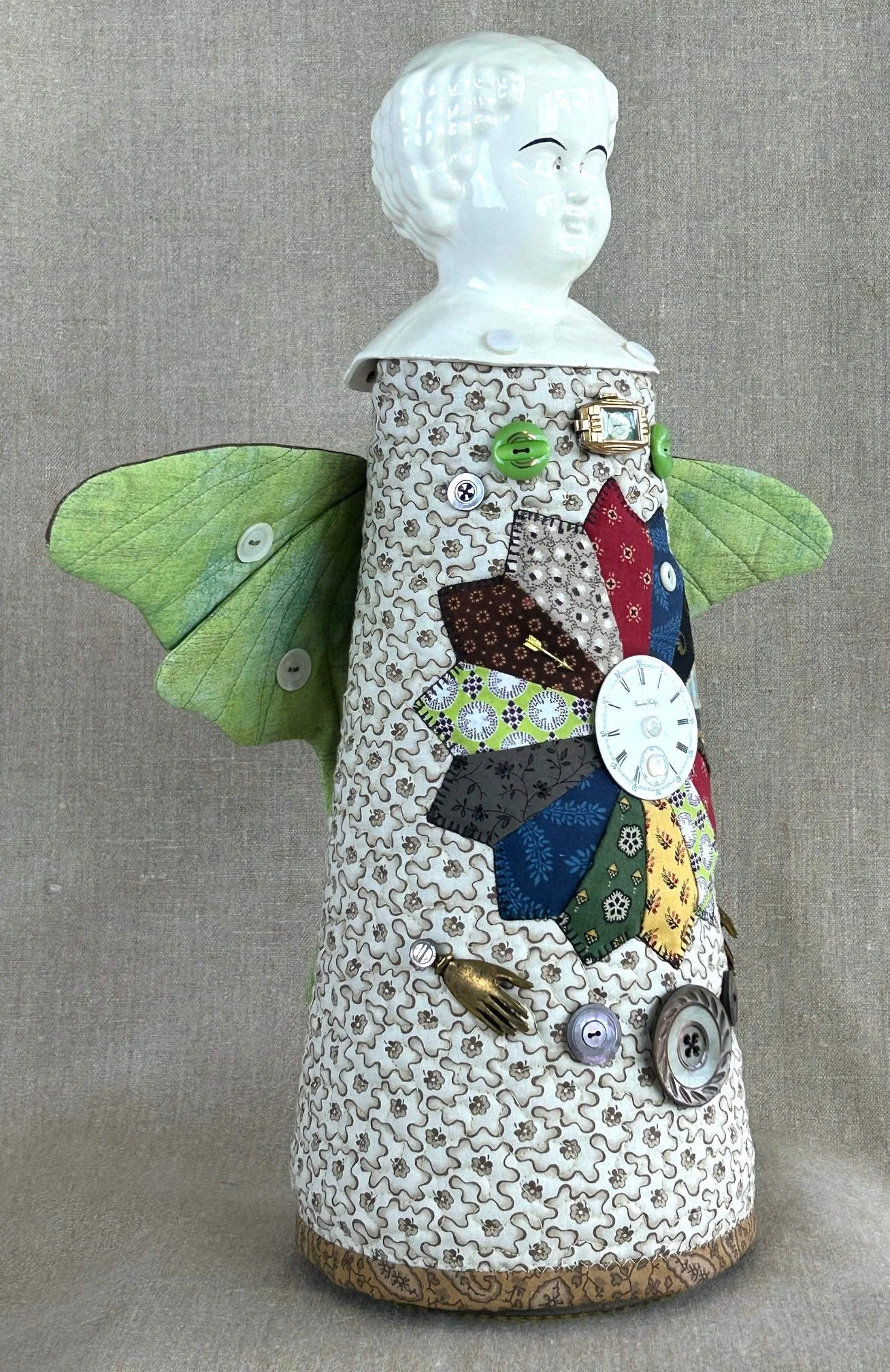 side view of a folk art doll featuring decoration with vintage glass buttons and trinkets