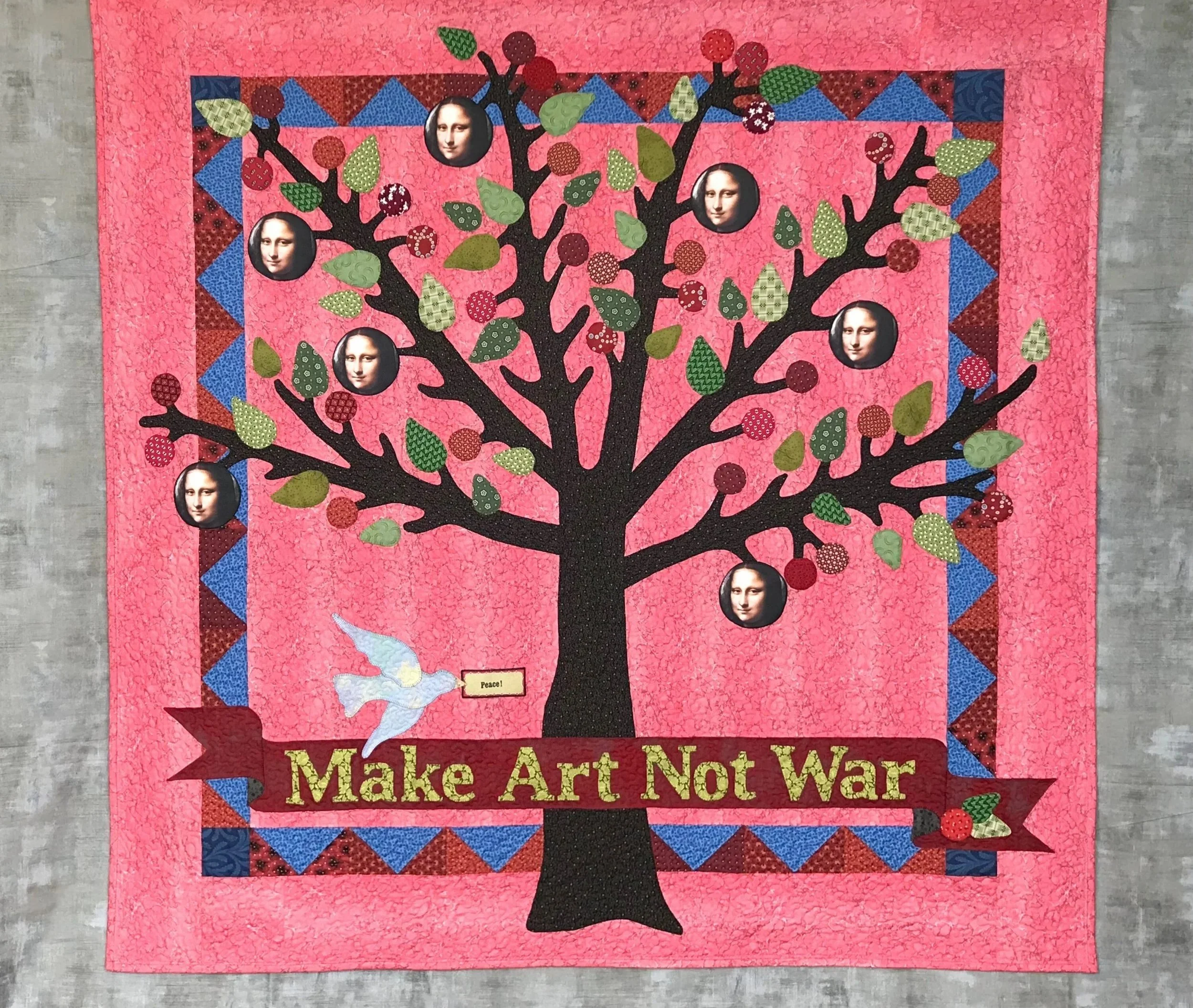 Fine Art Quilt Wall hanging featuring an applique tree and text that reads Make Art Not War