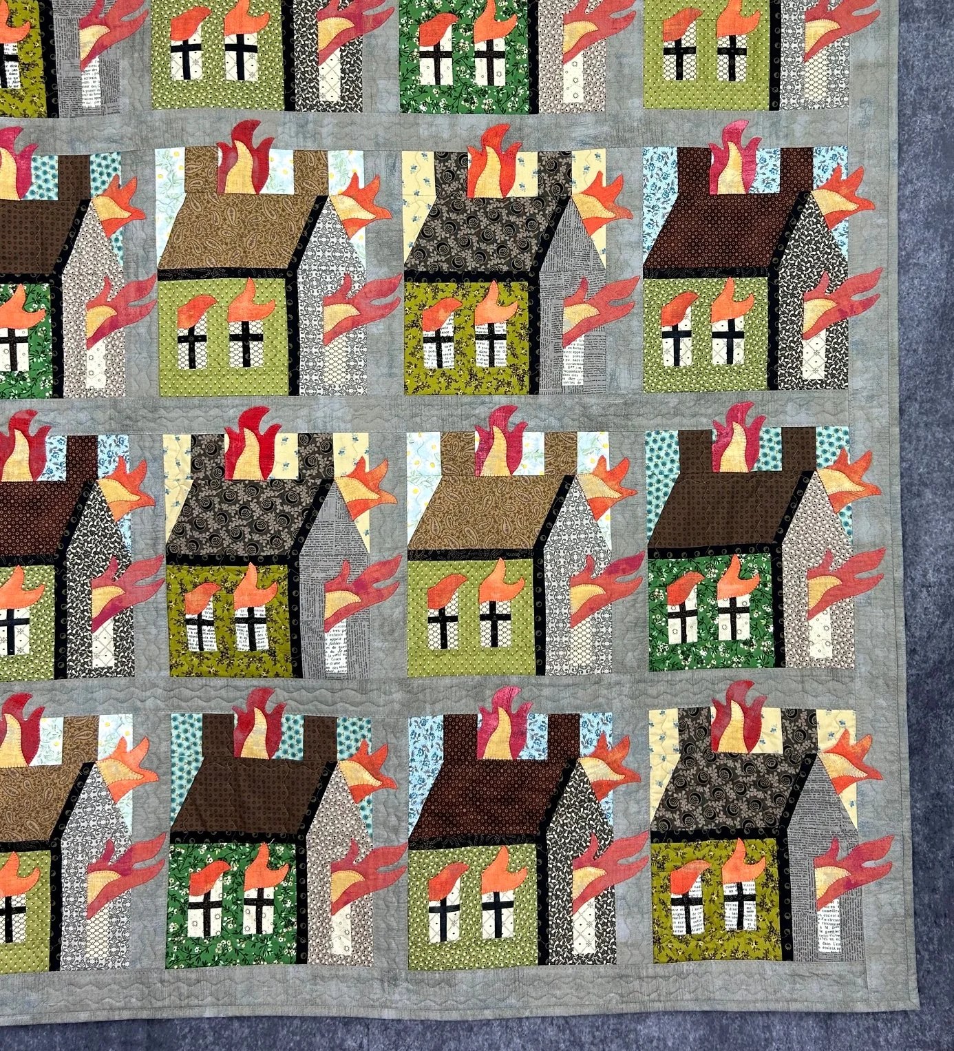 gray border art quilt with applique houses on fire design
