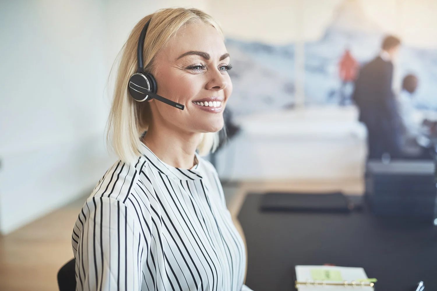 A VDS Genesys Cloud specialist smiling while wearing a headset in a contact center