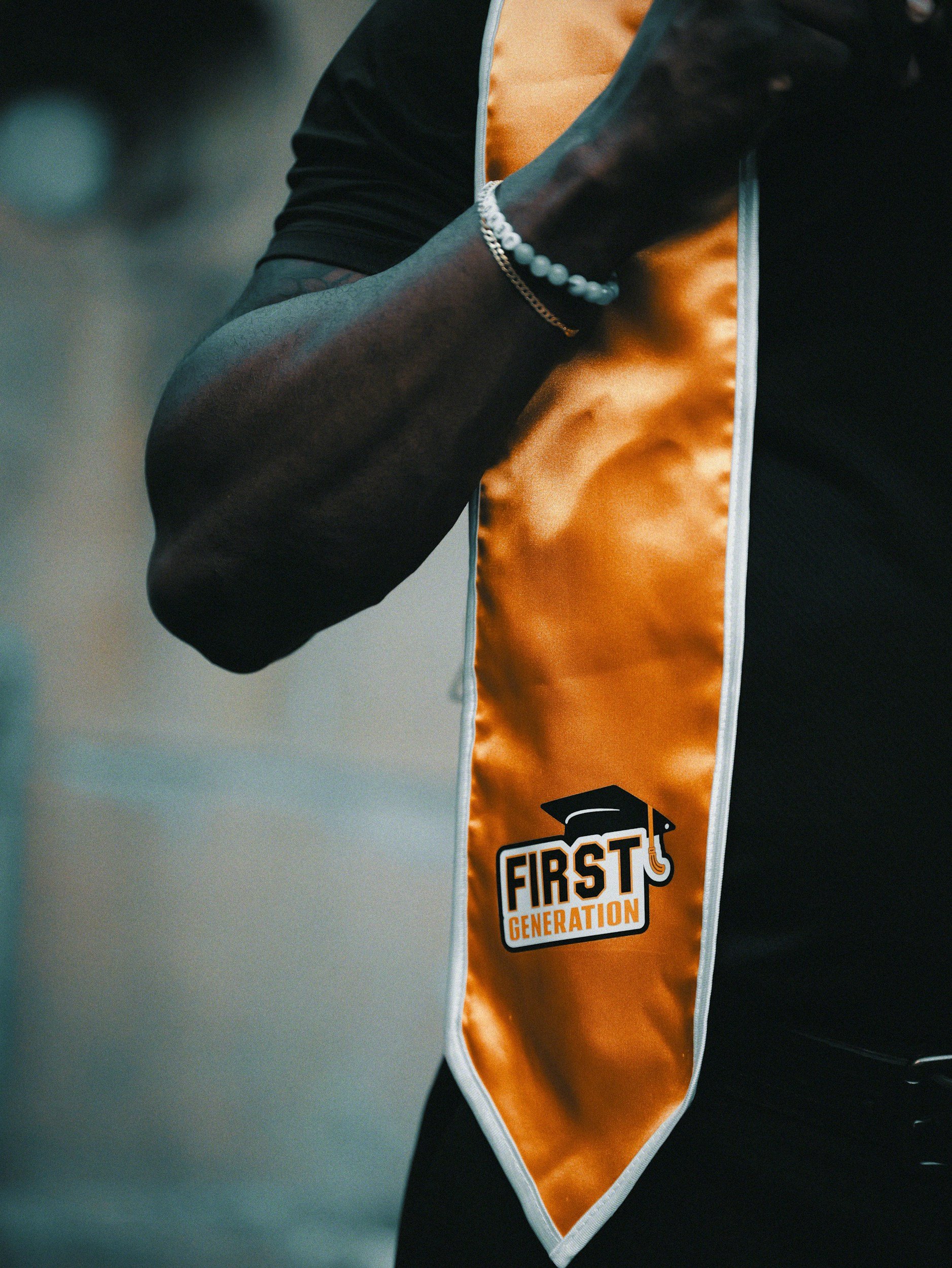 a person wearing a sash that says 1st generation during a graduation