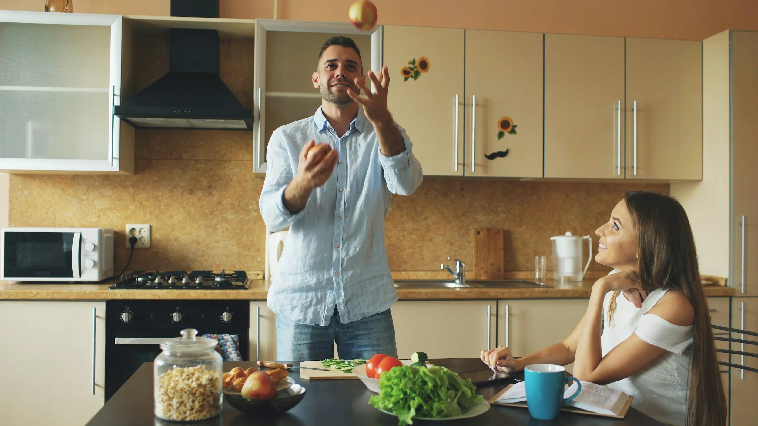 a person juggling onions in a kitchen