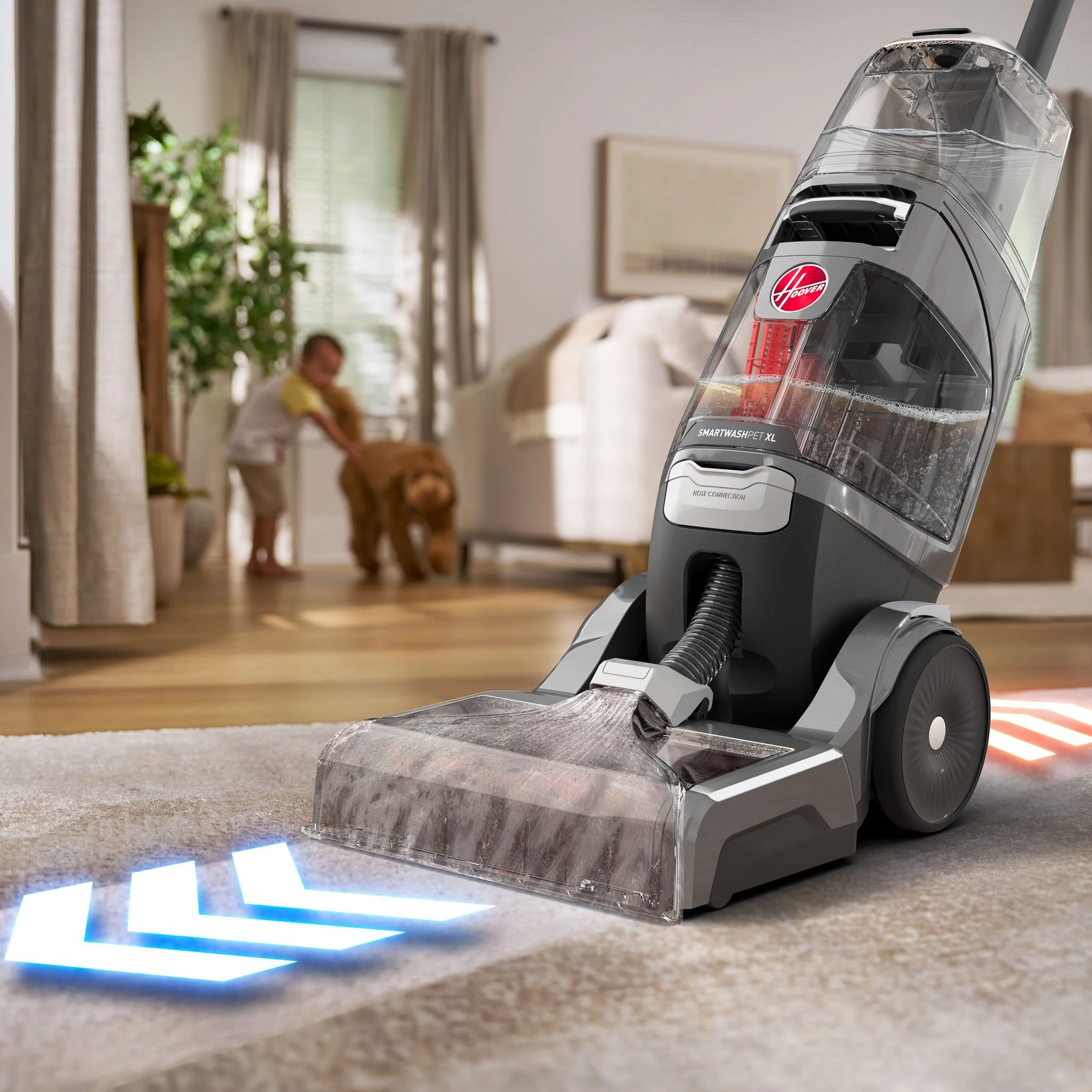 Hoover carpet washer cleaning an entry rug with a child and dog playing in the background