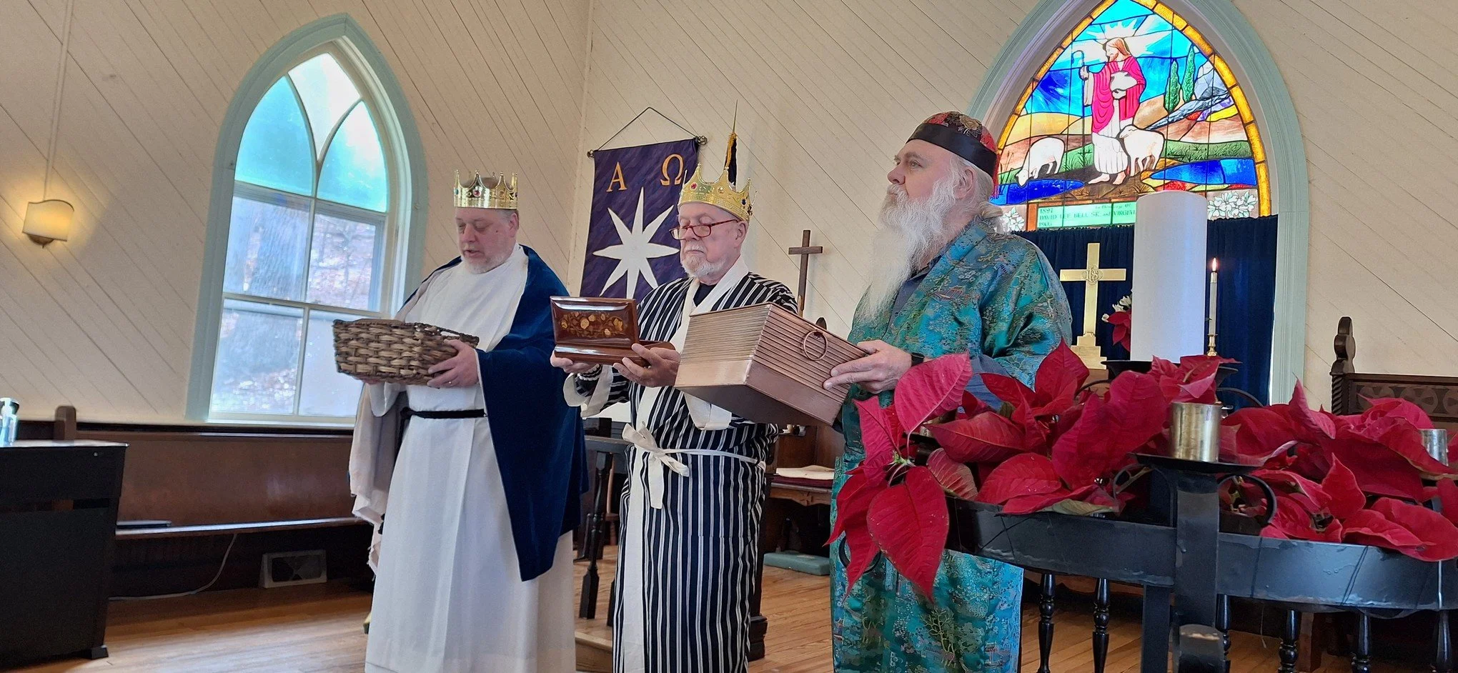 Three men dressed as kings or wise men standing inside a church, holding boxes or gifts, with stained glass windows and church symbols in the background.