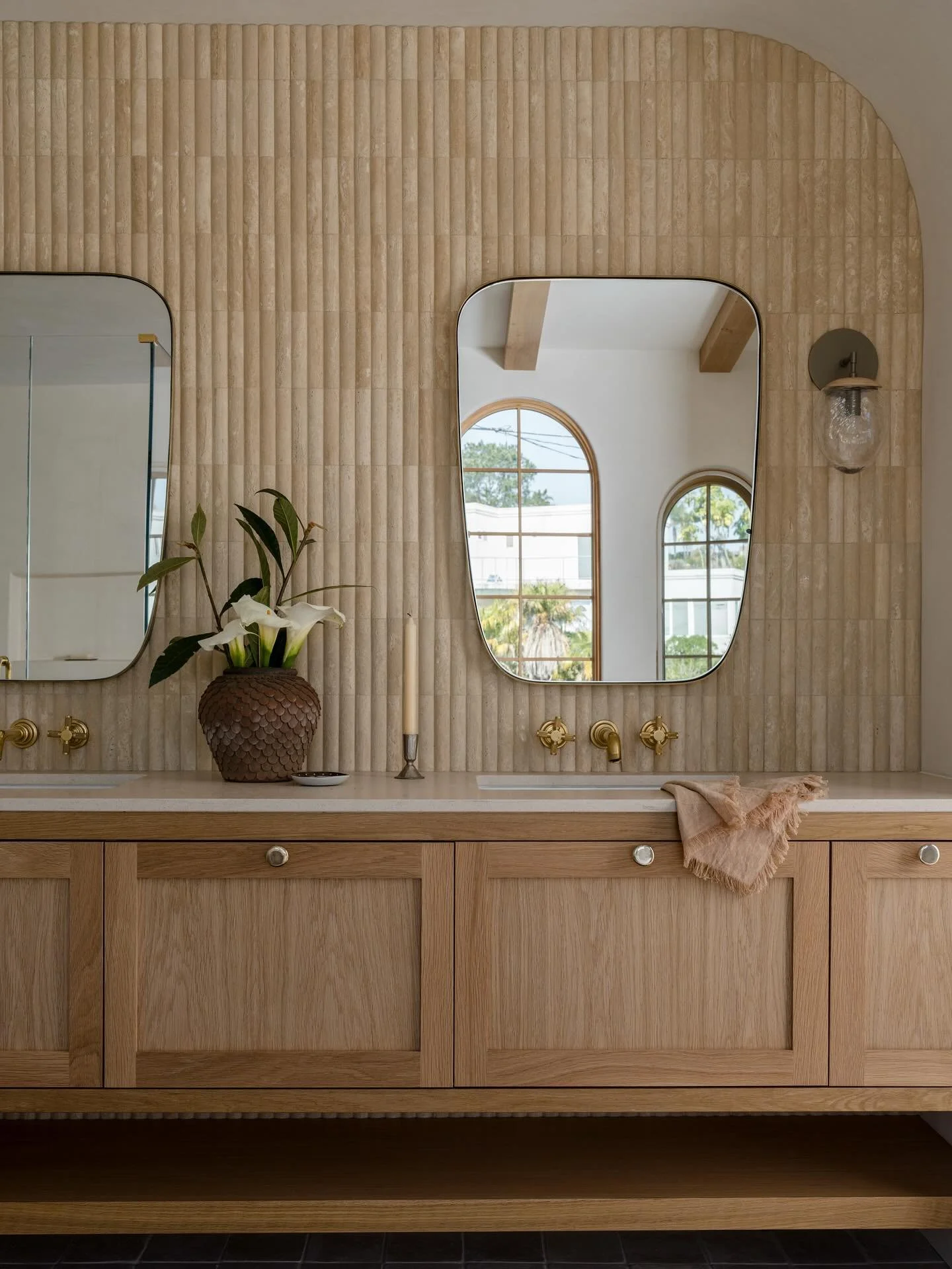 A glimpse into the main bathroom at our Canyon project. We arched the walls surrounding the vanity and fully clad the back wall in a rounded travertine. It&rsquo;s neutral, but it&rsquo;s far from boring. 

Design/Styling: @anaberdesign 
Architecture