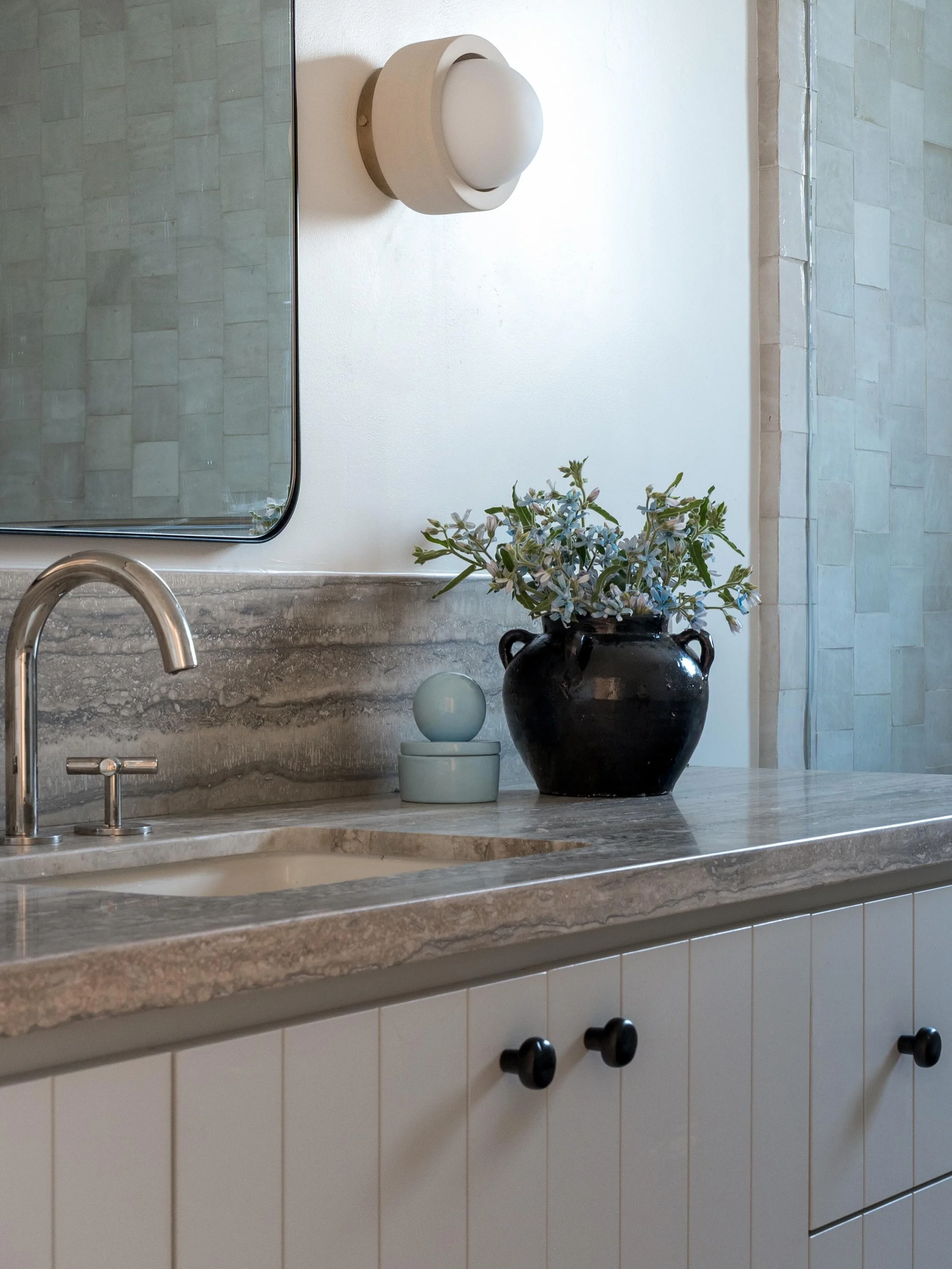 Silver travertine, faint dusty blue, and black iron hardware for this girls bathroom at our #aNDsunset project ✨

Design/Styling: @anaberdesign 
📷: @charlotteleaphotography 

#bathroom #bathroomdesignideas #sodomino #travertine