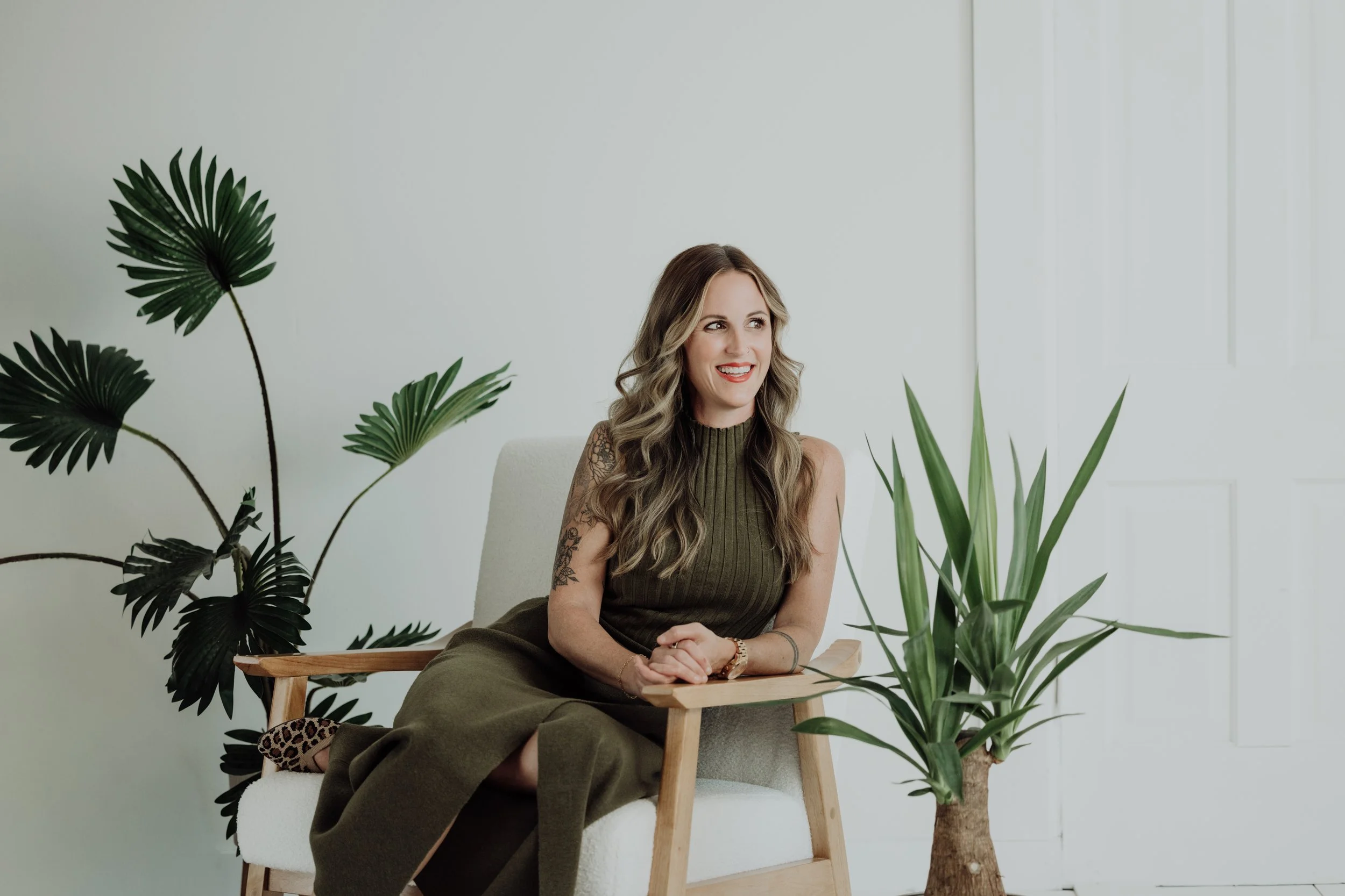 Woman sitting on a chair with plants in a bright room