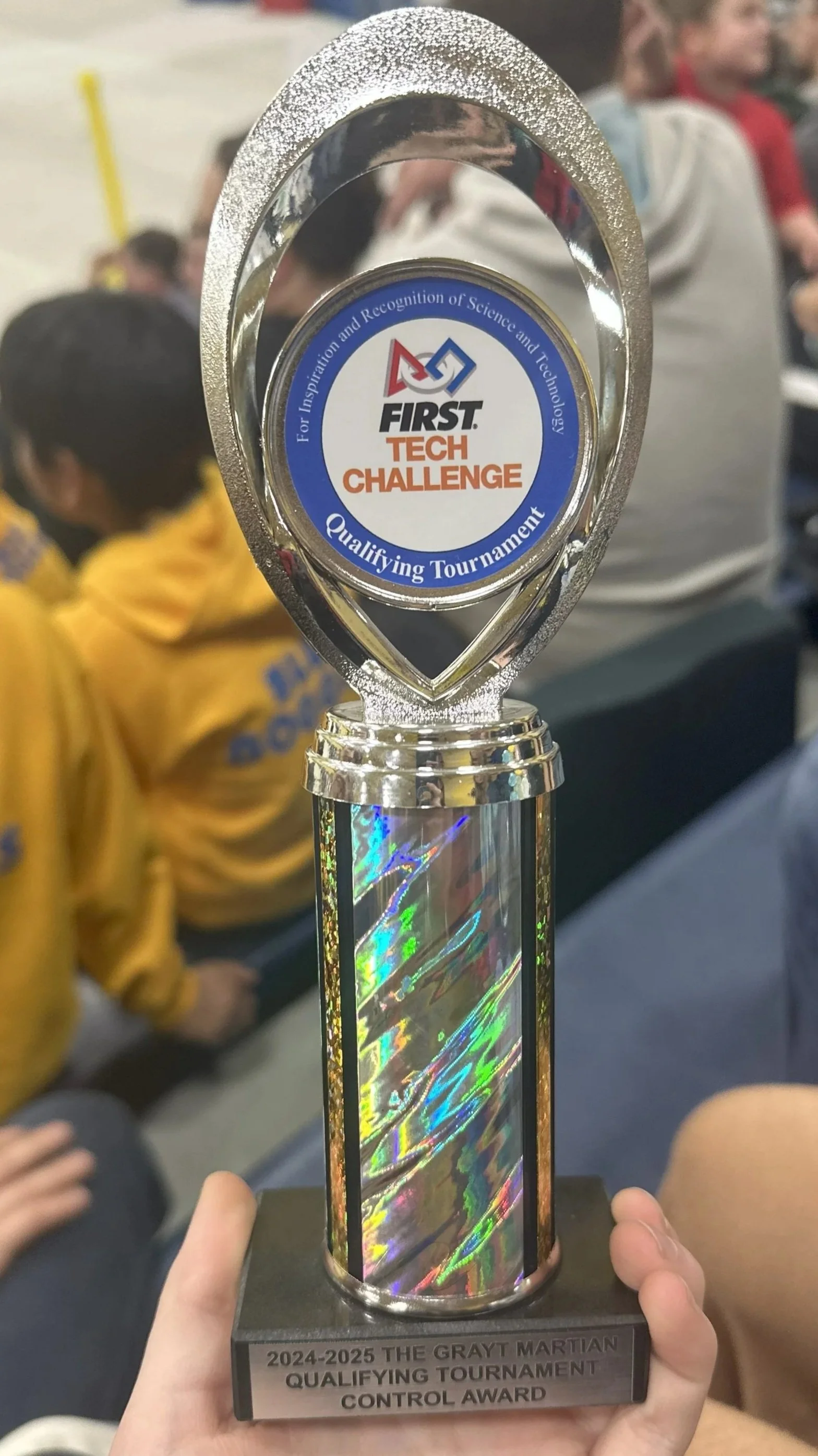 A trophy with a holographic column and a circular top displaying the FIRST Tech Challenge logo. The base reads "2024-2025 The Grayt Martian Qualifying Tournament Control Award."