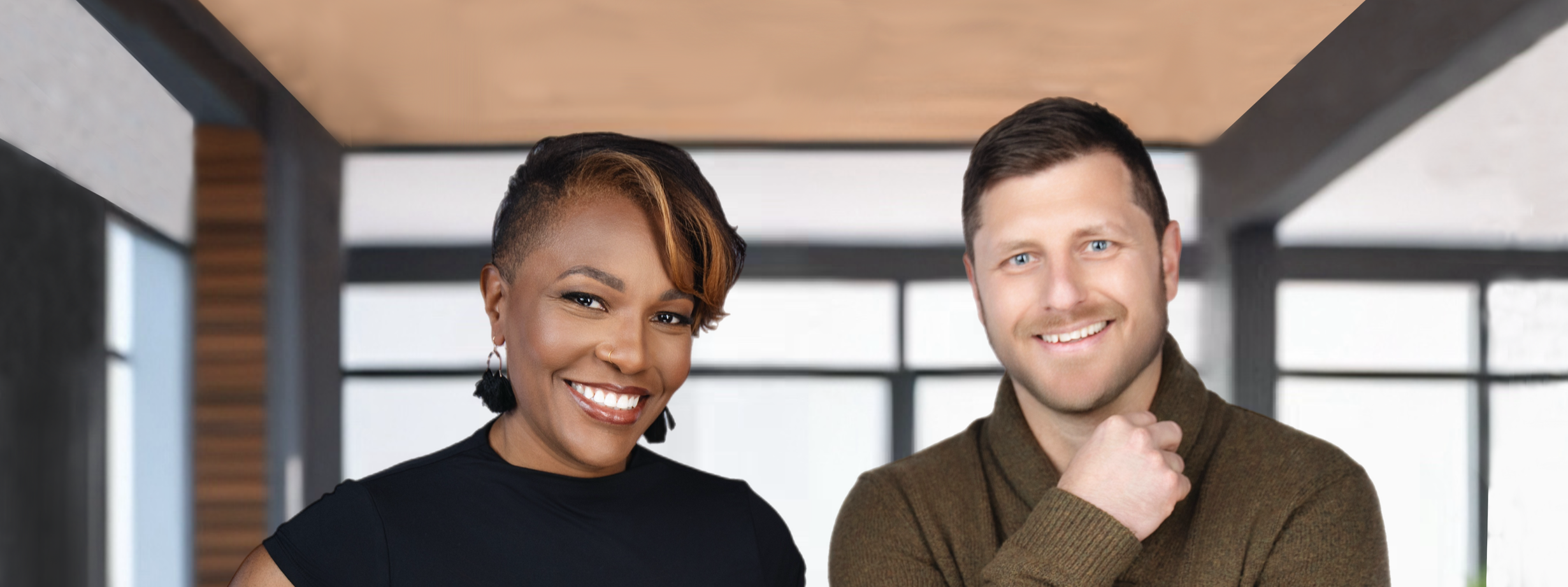 A woman and a man smiling indoors with large windows and modern decor in the background.