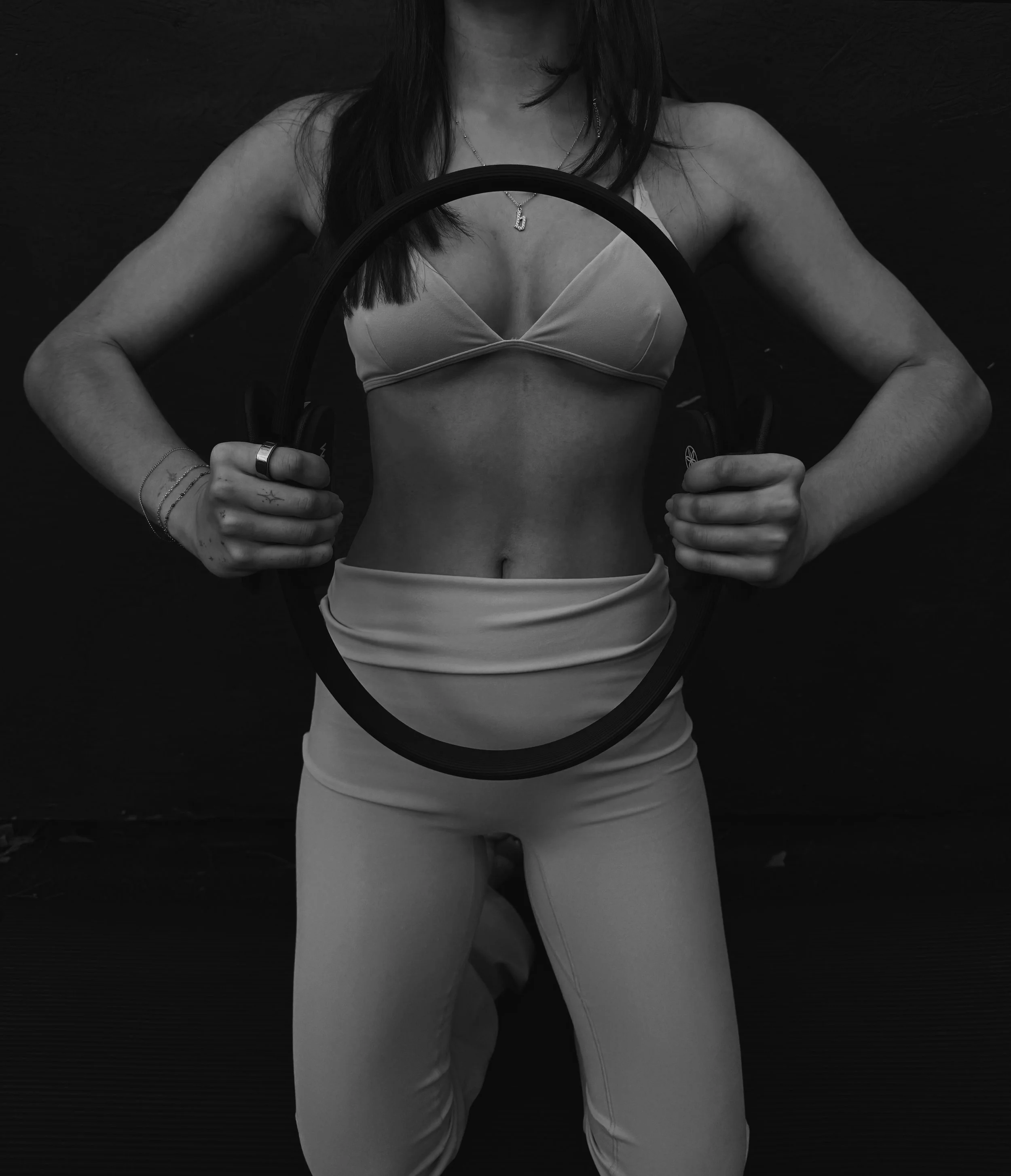 Holding Pilates ring flexed in front of body
