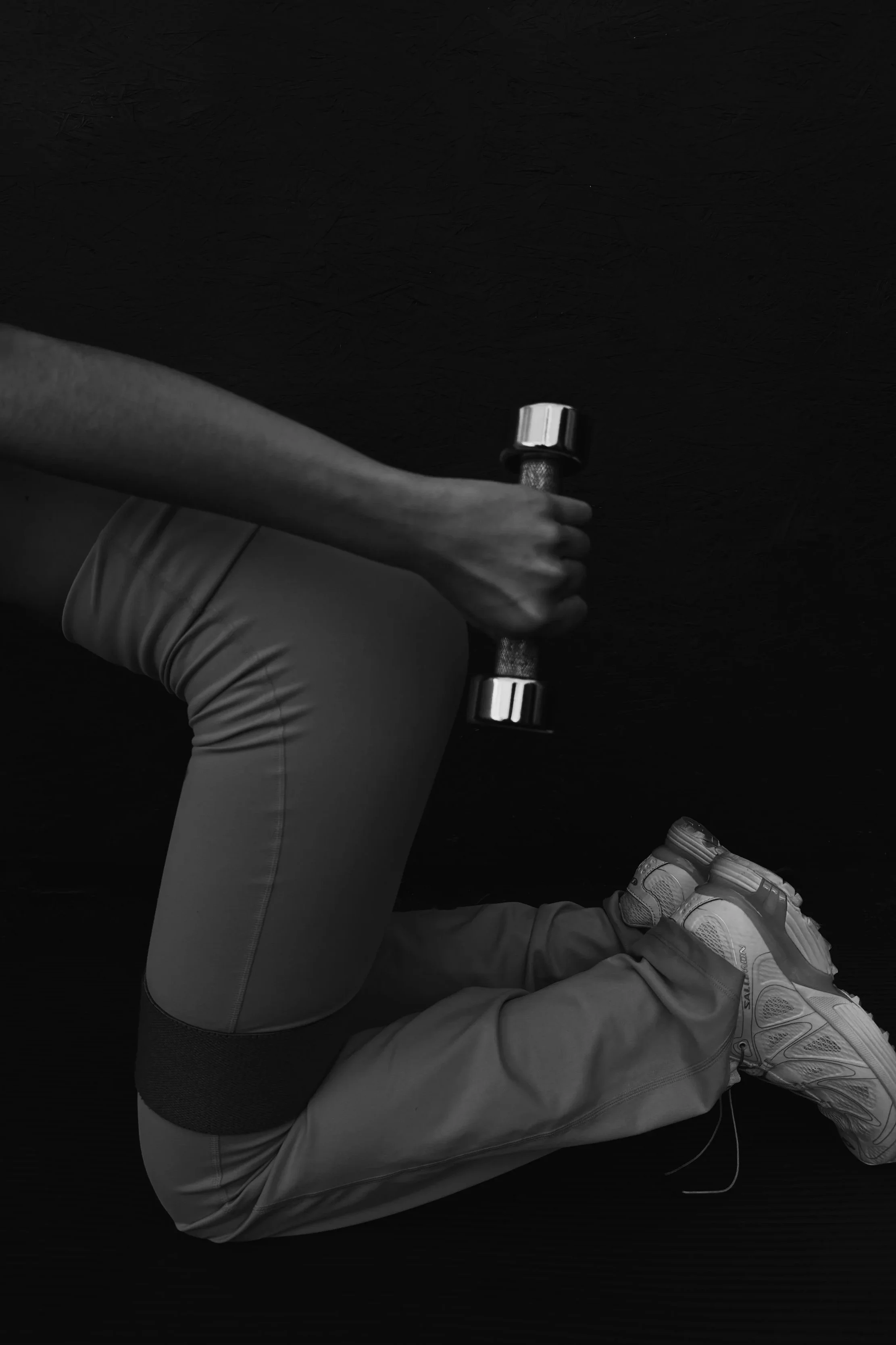 Pilates pose, knees on the ground with dumbbell in hand extended backward