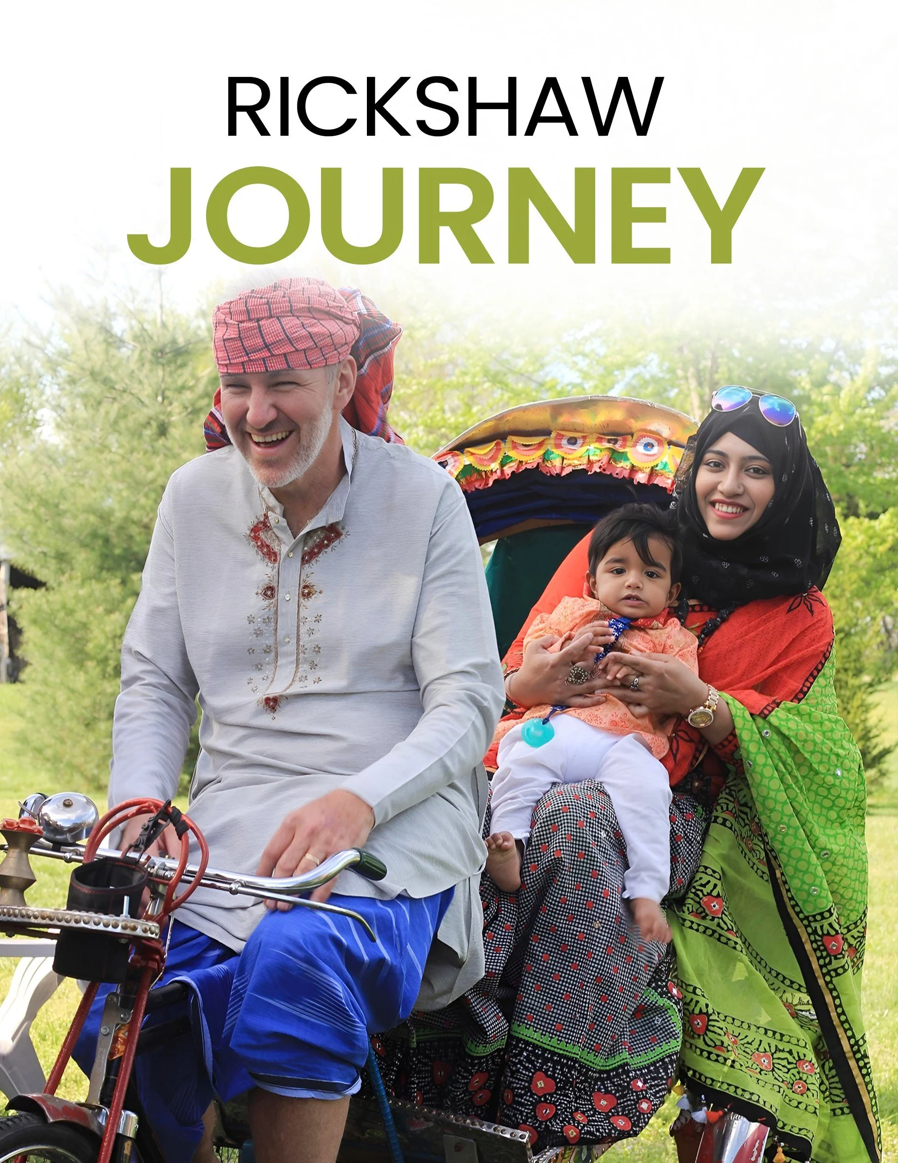 A smiling man riding a bicycle with a woman and child sitting on the back, set outdoors with trees and greenery in the background.