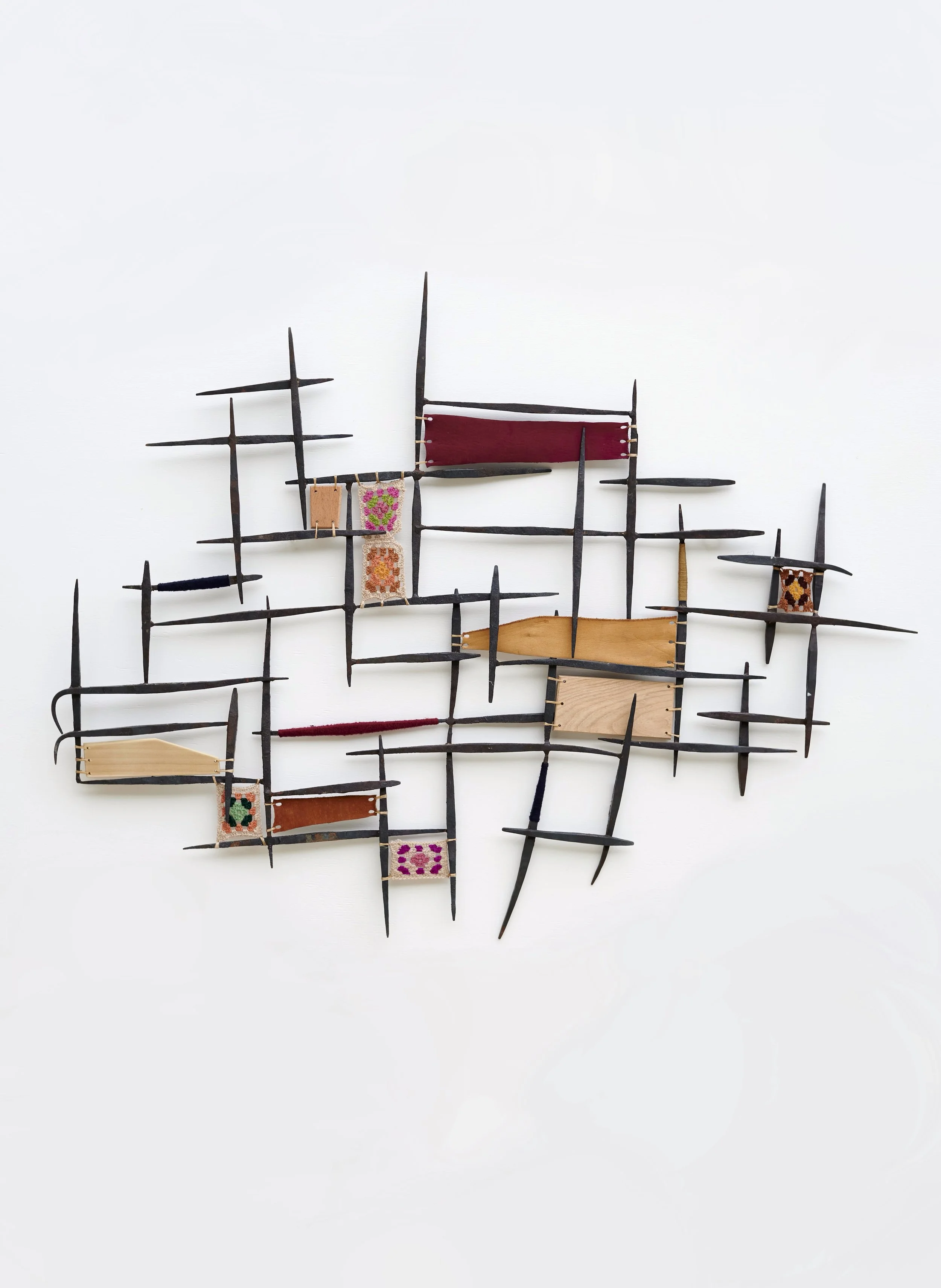 Material Reunion, 2025. Salvaged metal, vintage scrap leather, crocheted granny squares, scrap wood, vintage embroidery floss.