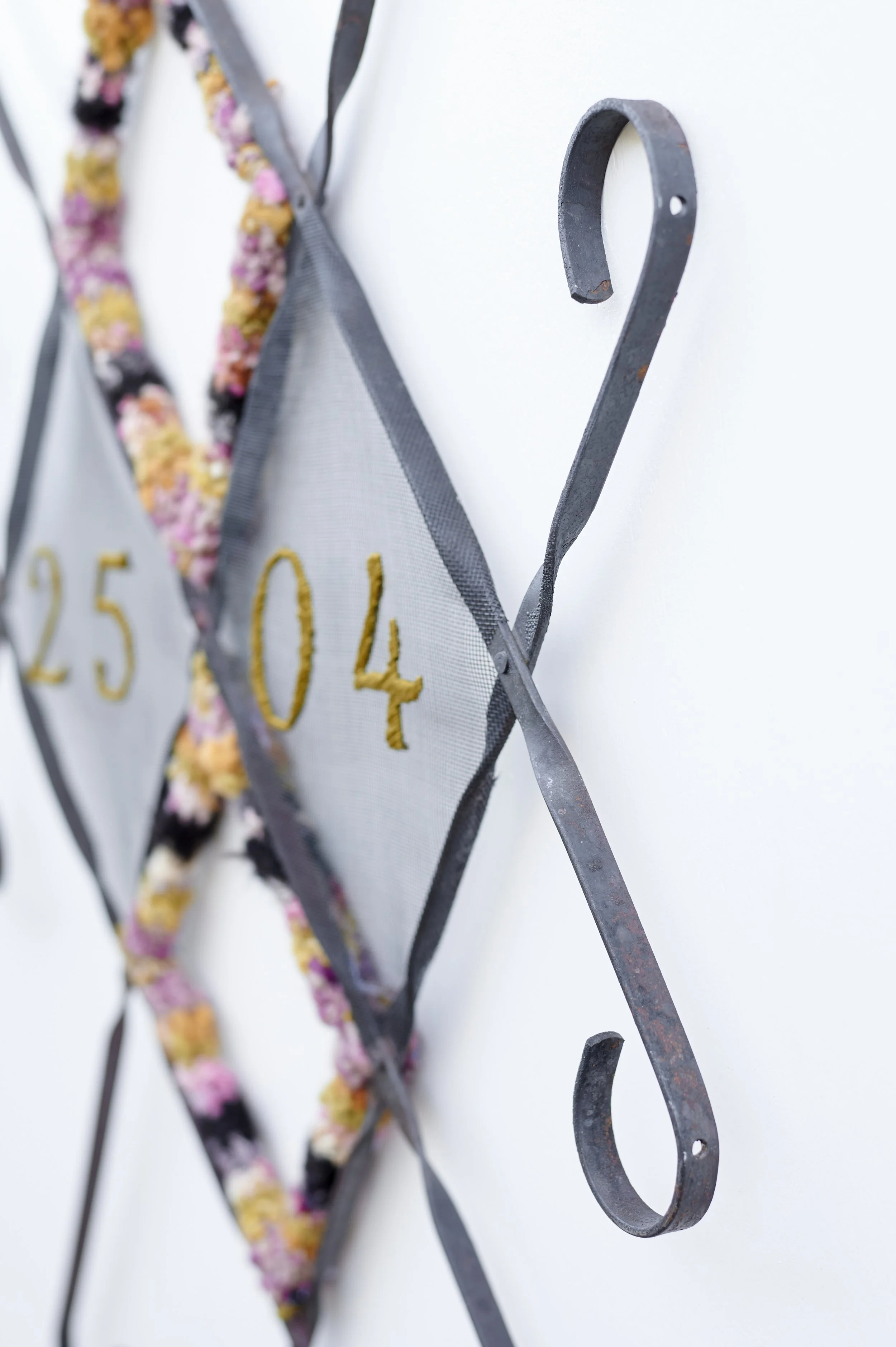 Homecoming (detail) 2026. Salvaged screen door frame, screen, heirloom textile, embroidery floss.