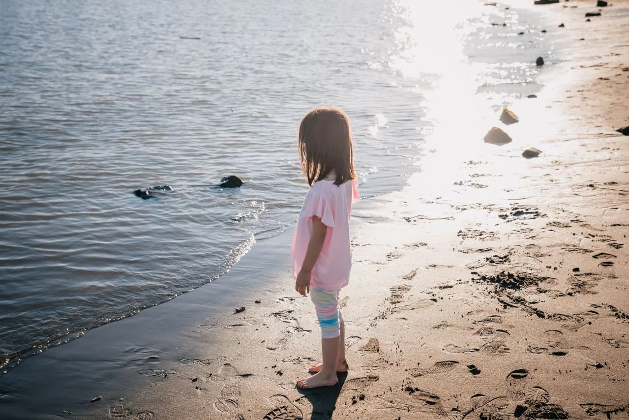 A young girl looking at the ocean