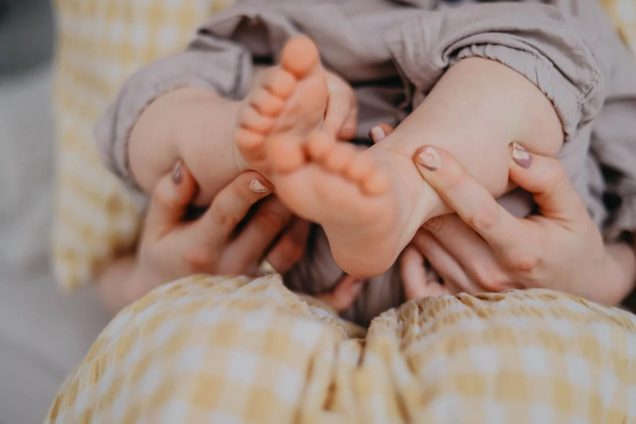 A mother holding her child’s feet