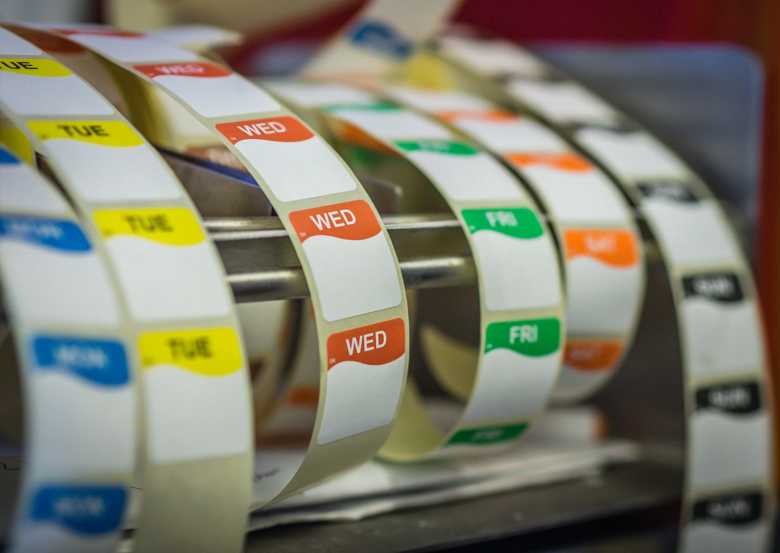 Spiral of calendar pages featuring color-coded day labels, such as 'TUE', 'WED', and 'FRI'.