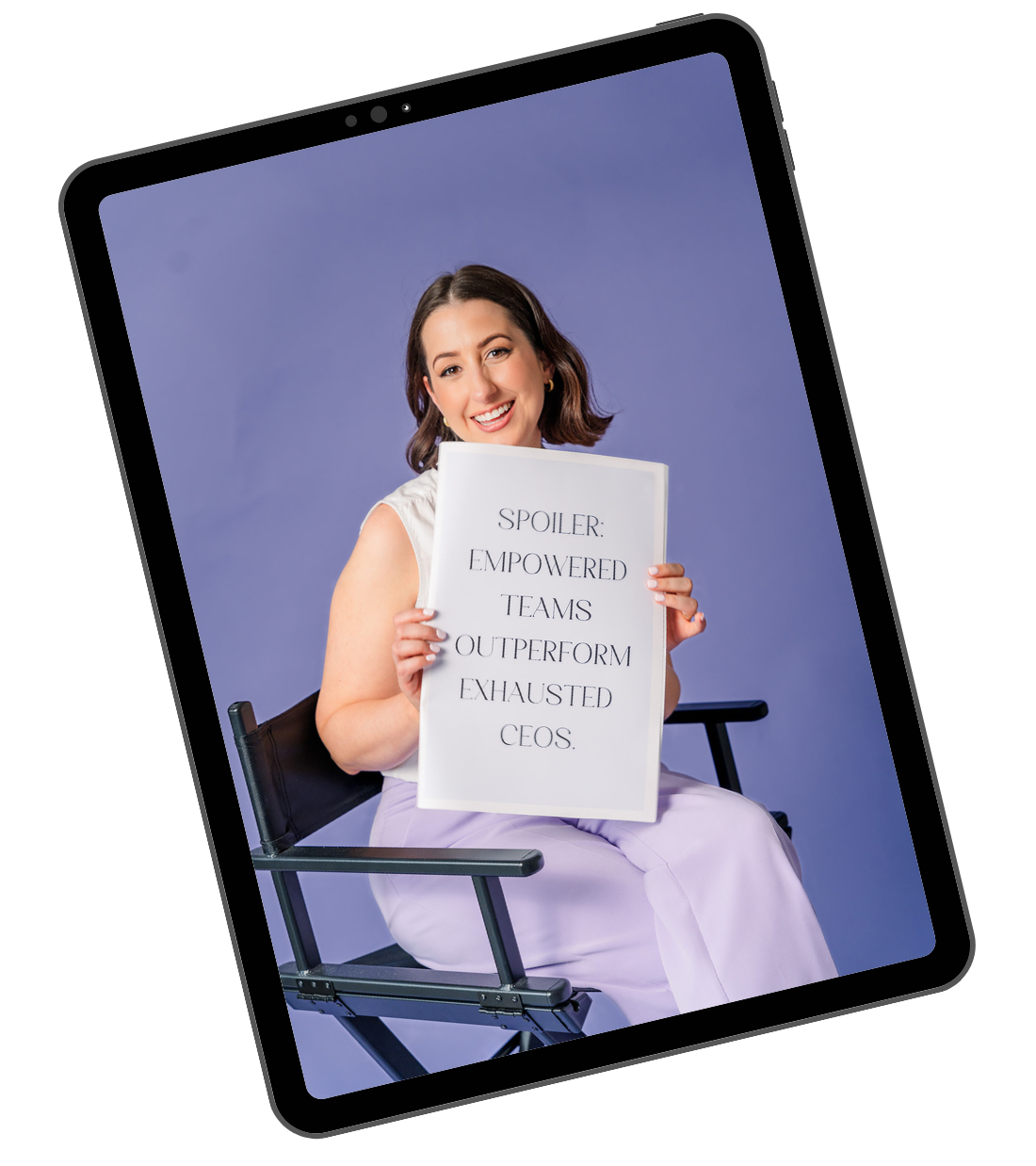 CEO sitting on a chair holding a sign that reads, 'Spoiler: Empowered teams outperform exhausted CEOs,' smiling at the camera with a purple background.