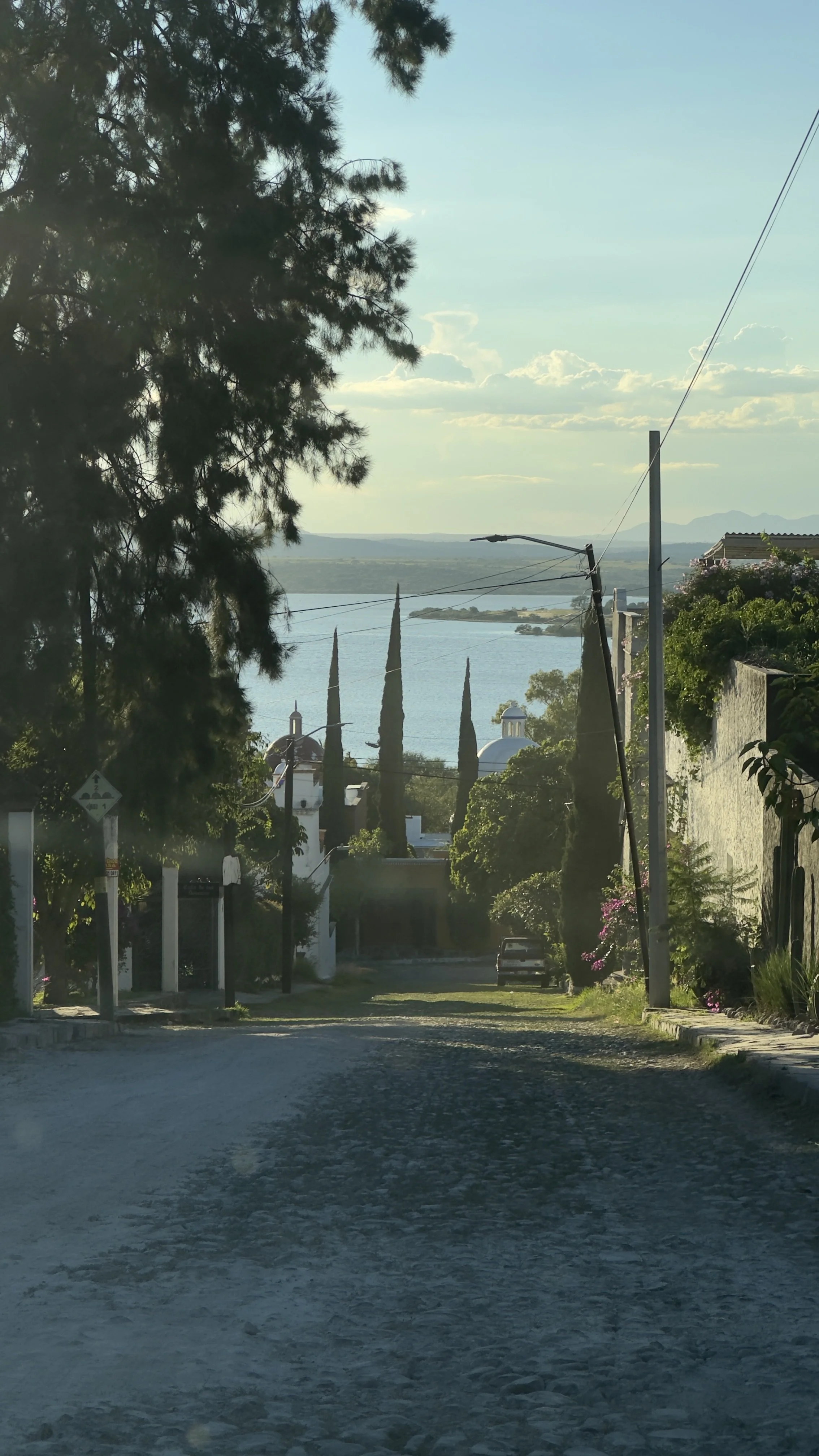 Street view in the Los Frailes neighborhood of San Miguel de Allende with the Presa Allende in the distance