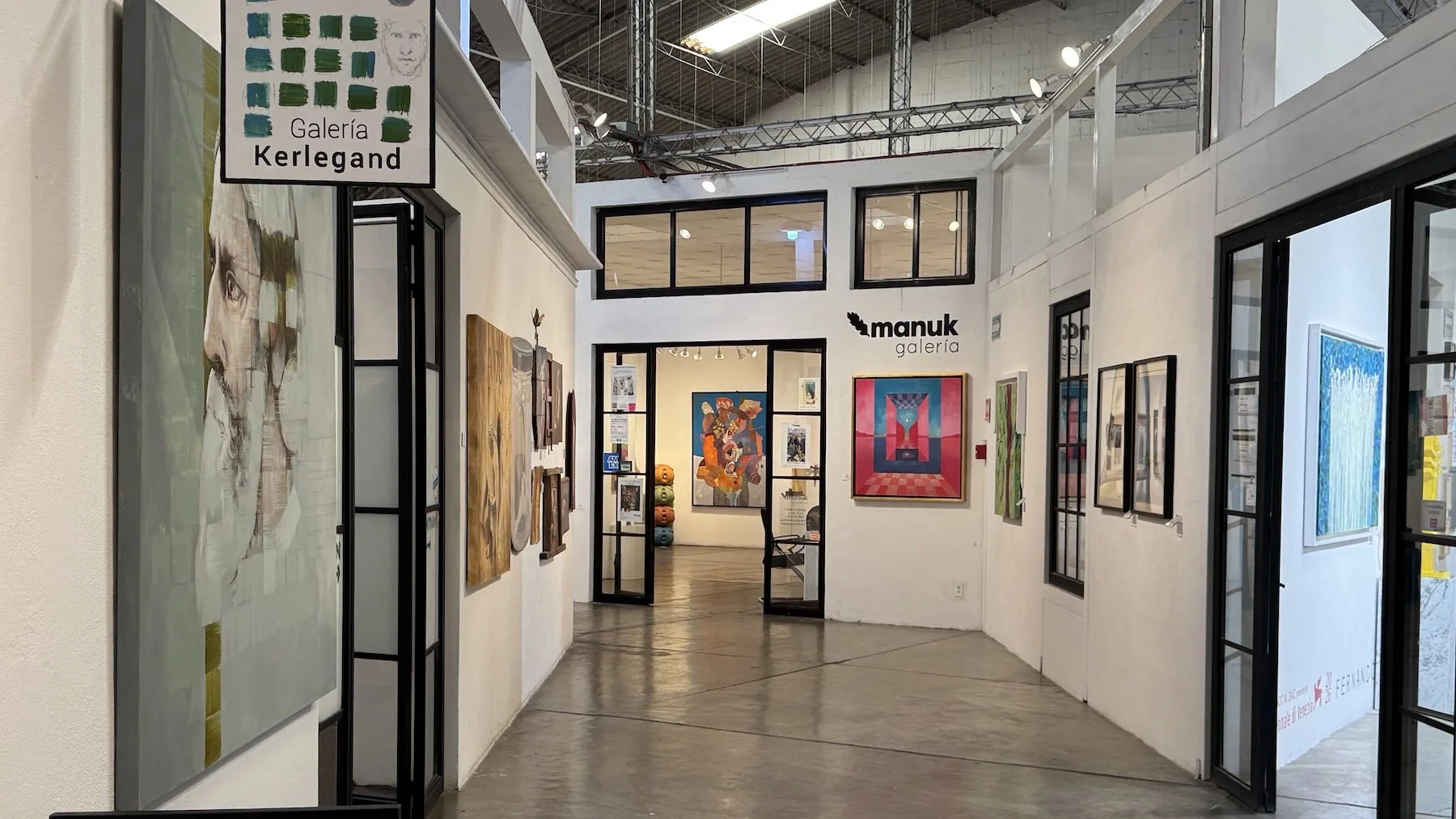 Hallway at Fábrica La Aurora with signs pointing to different art galleries in San Miguel de Allende