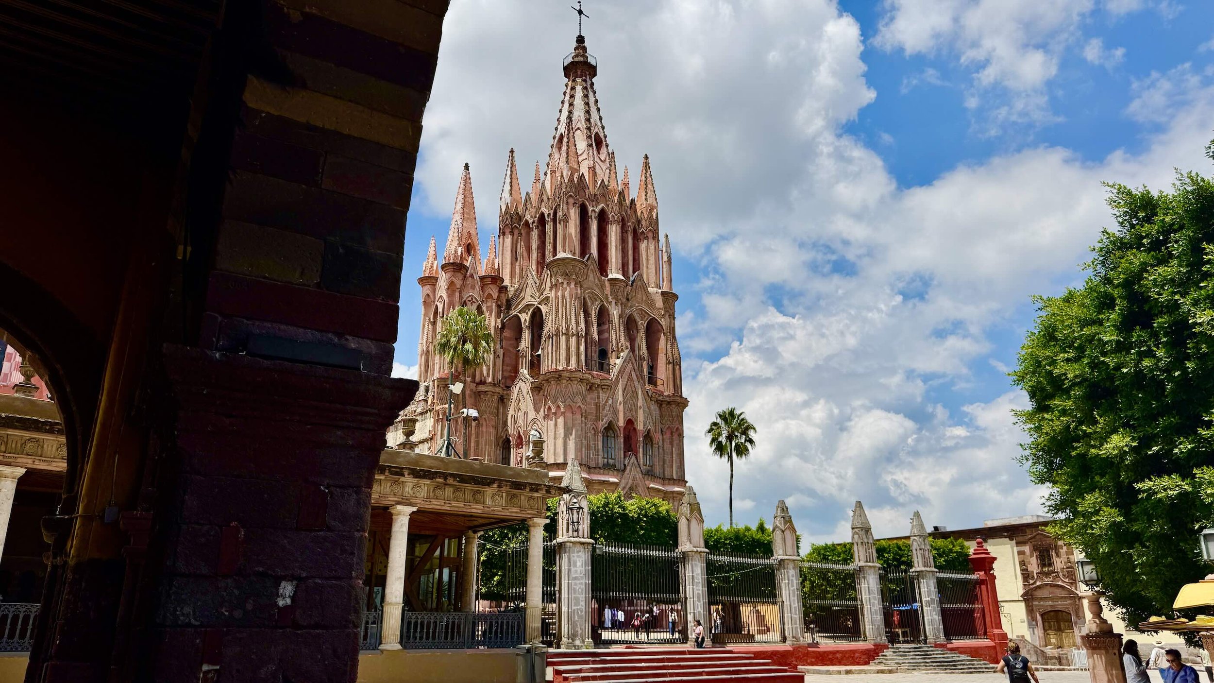 he pink Neo-Gothic towers of the Parroquia de San Miguel Arcángel rising above the Jardín Principal in San Miguel de Allende. Through and Archway