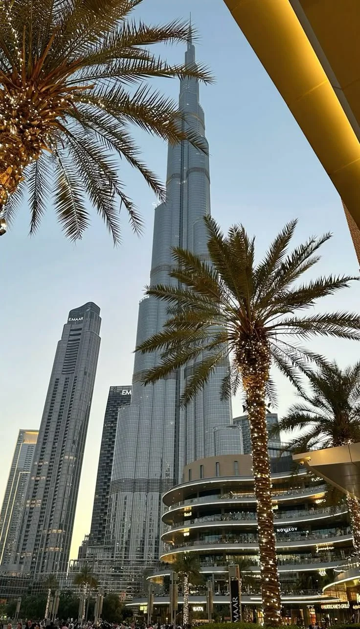 Tall skyscraper in Dubai with palm trees in the foreground.