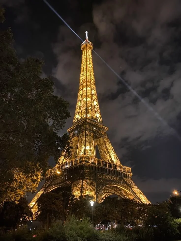 Ground level view of the Eiffel tower sparkling at night aesthetic