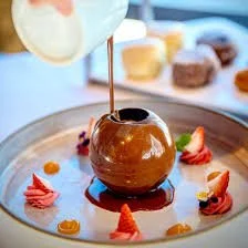 Chocolate dessert with caramel Sauce and strawberries on a plate