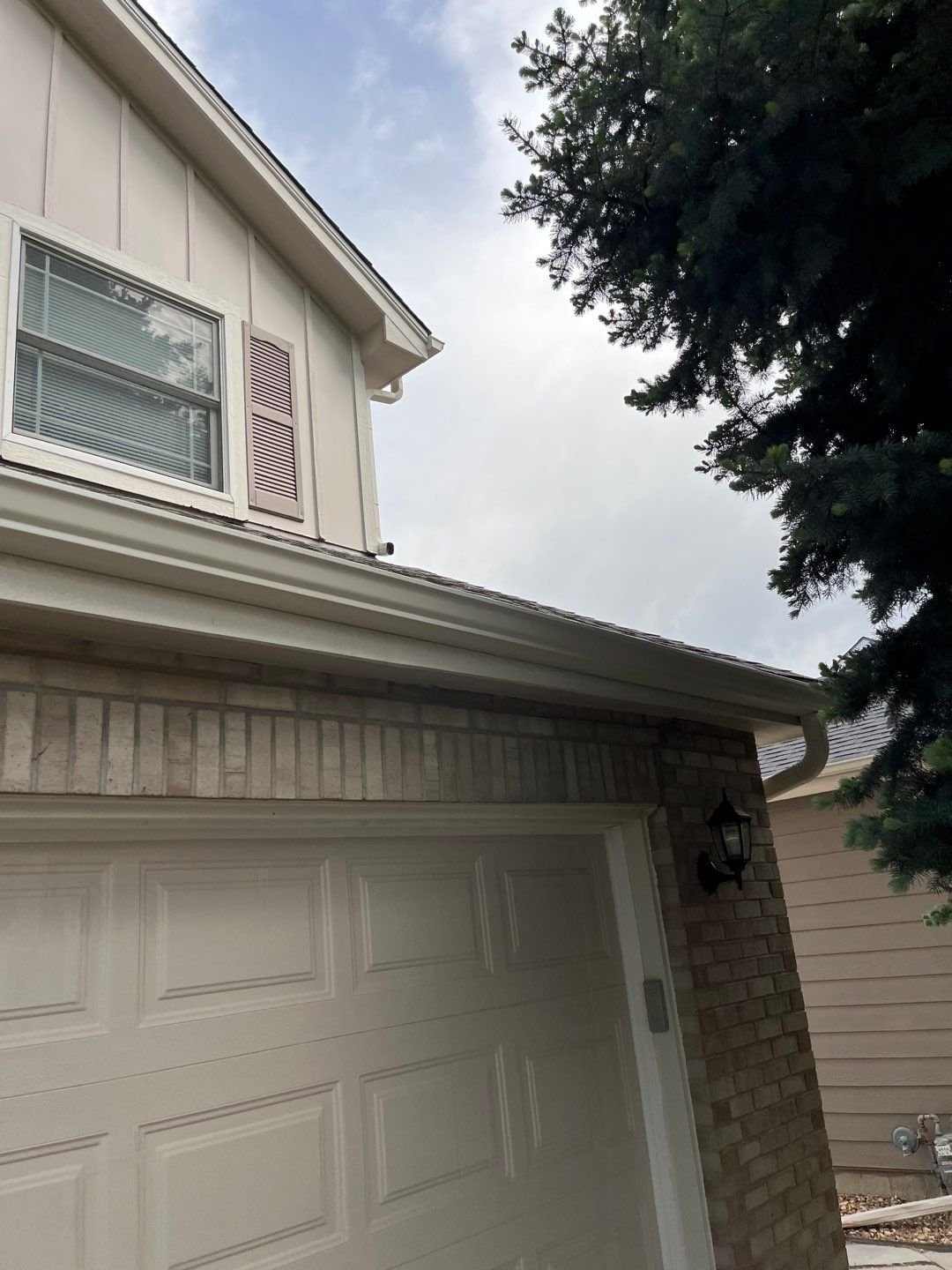 Linen-colored 5-inch seamless gutter and downspout installed above the garage of a Green Mountain home in Lakewood.