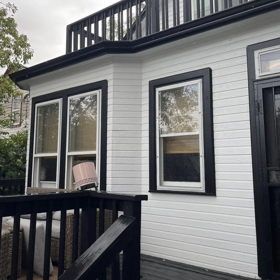 custom bay miters on seamless gutters installed on a home with a raised deck and multiple exterior windows.